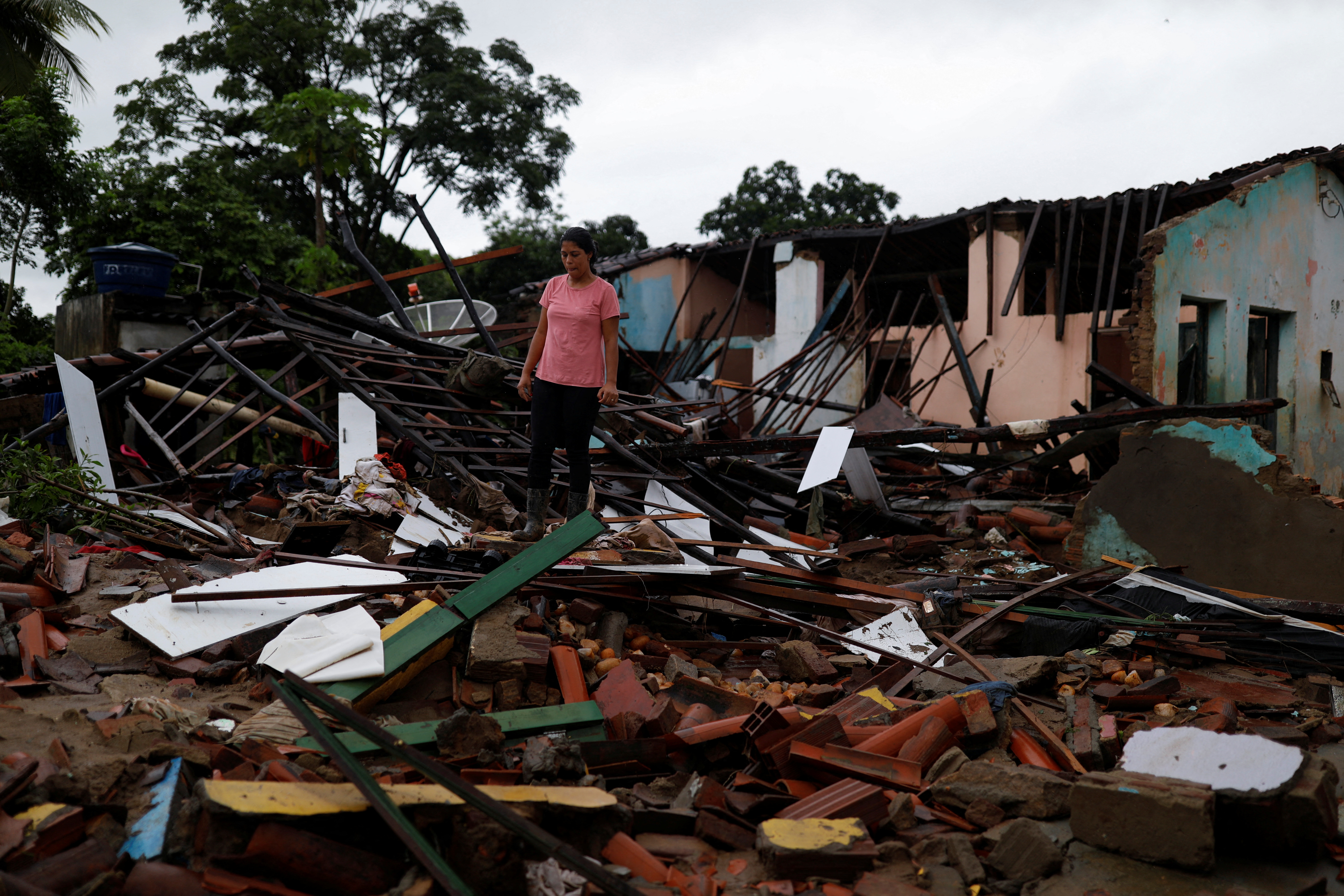 Juliana Reis, 37, stands near the rubble of her home which was destroyed by floods in Itambe, Bahia state, Brazil December 28, 2021. REUTERS/Amanda Perobelli