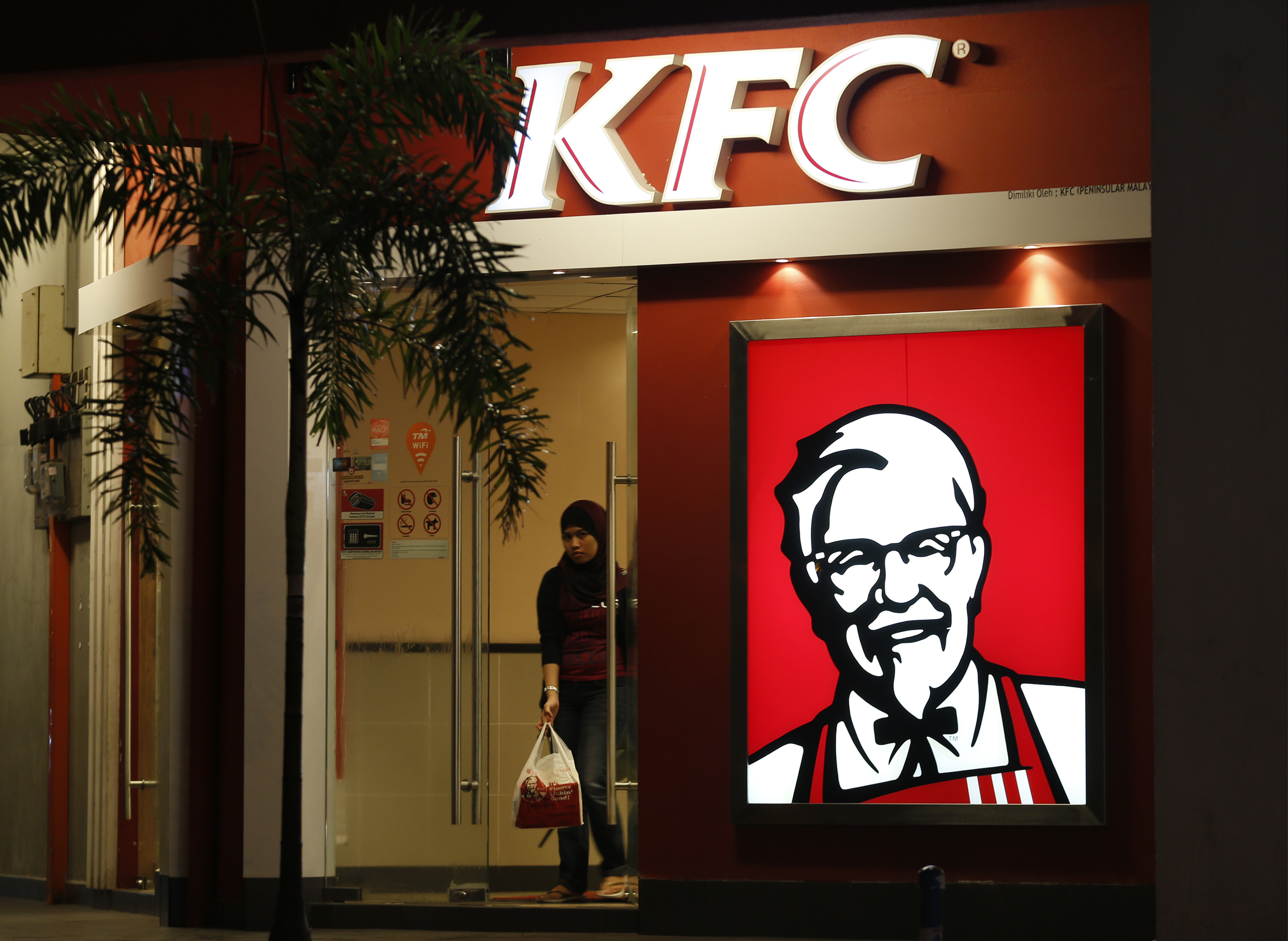 A customer leaves a KFC fast food restaurant in Dengkil