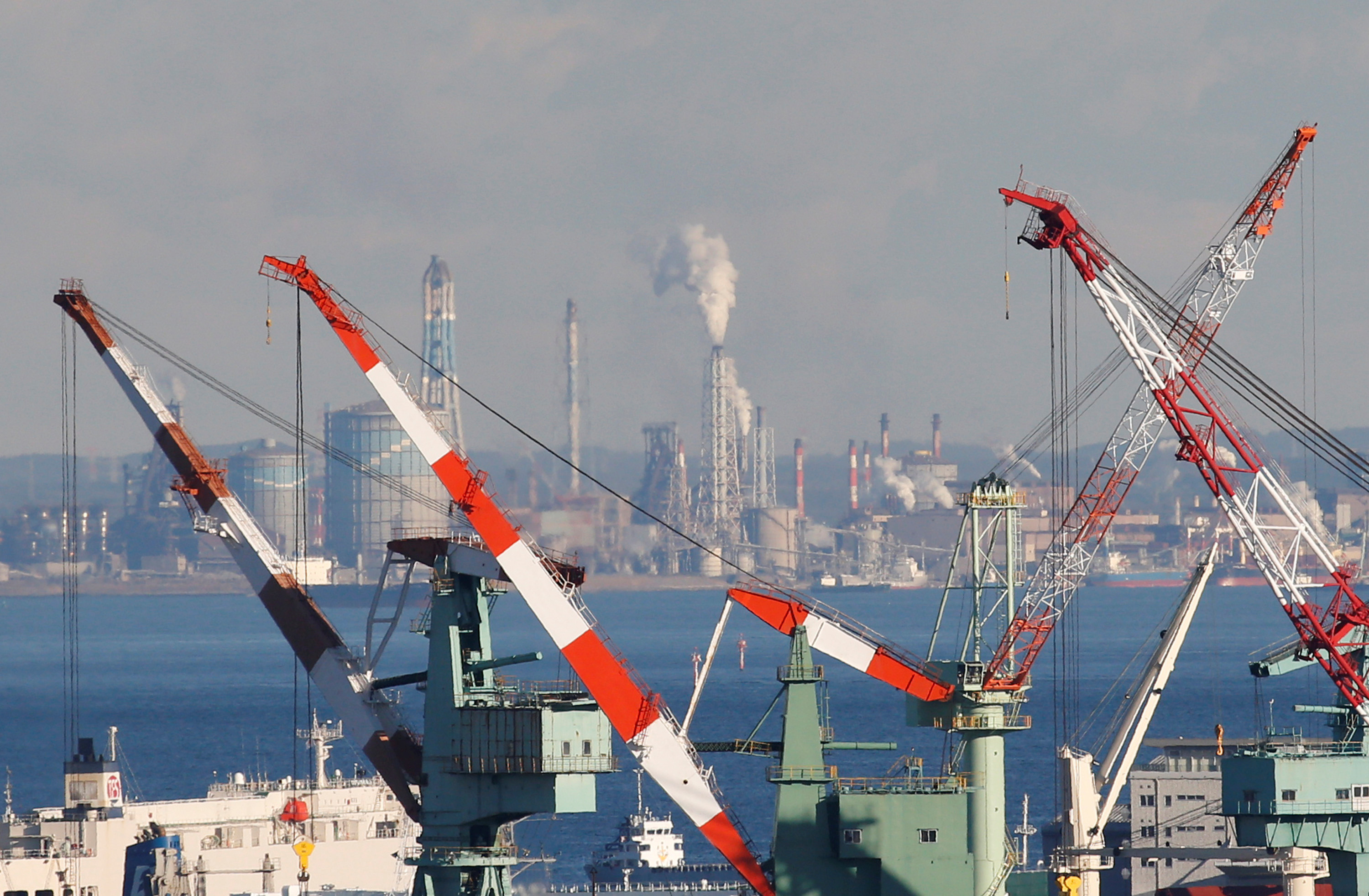 Chimneys and cranes are seen at an industrial area in Yokohama