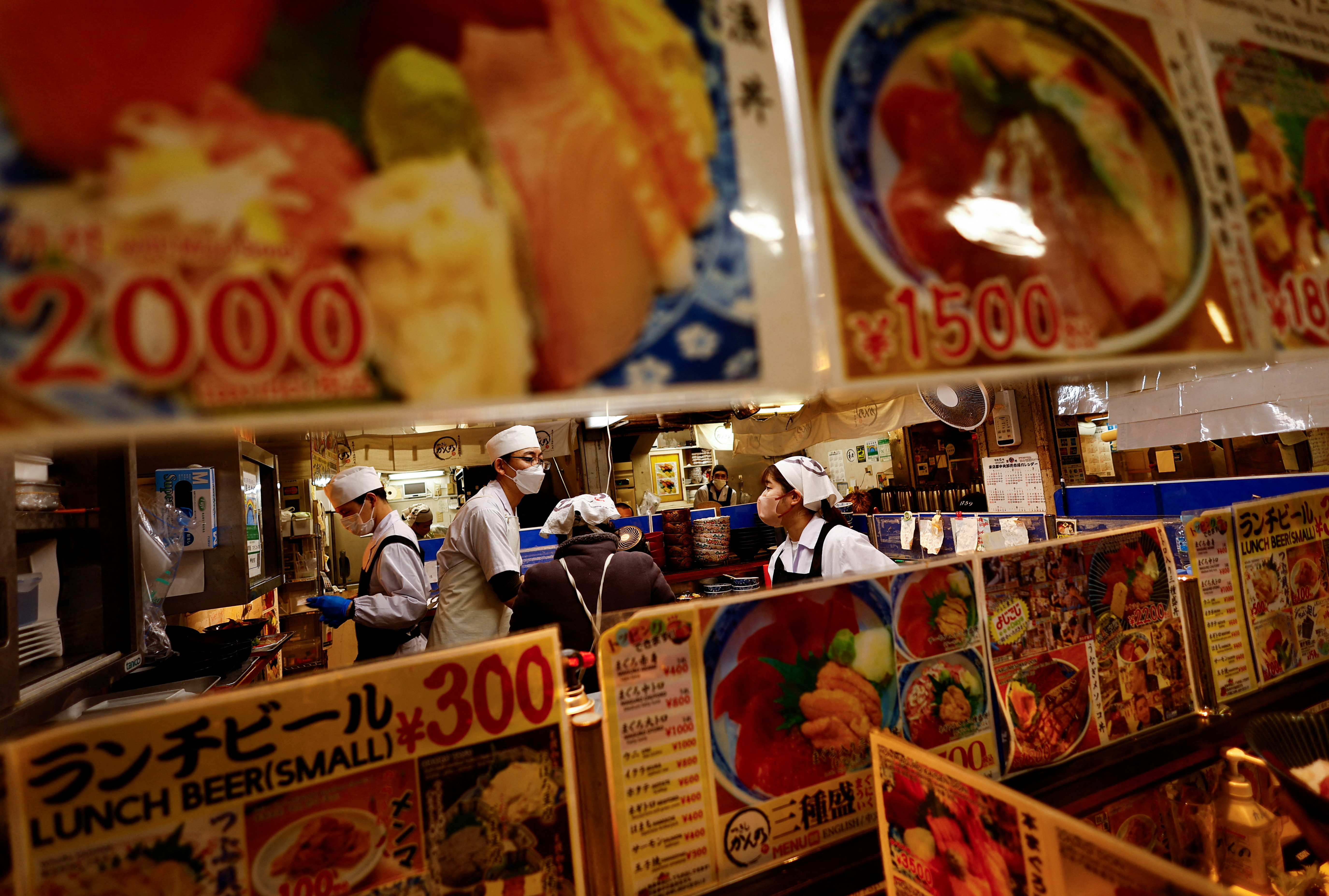 Employees of a seafood restaurant work in their kitchen space at Tsukiji Outer Market in Tokyo