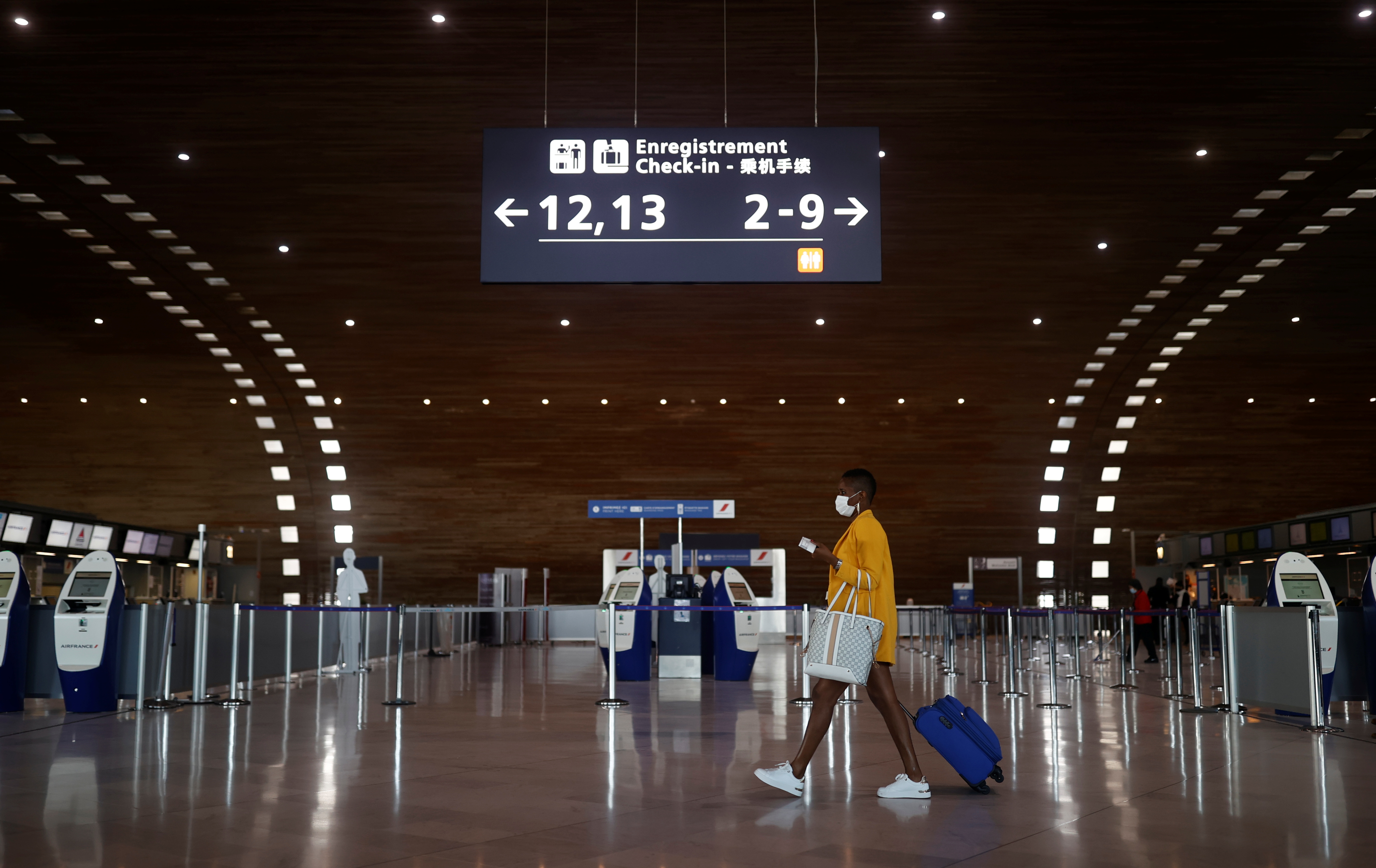 A woman makes her way in the departures area of the Terminal 2E at Charles-de-Gaulle airport in Roissy