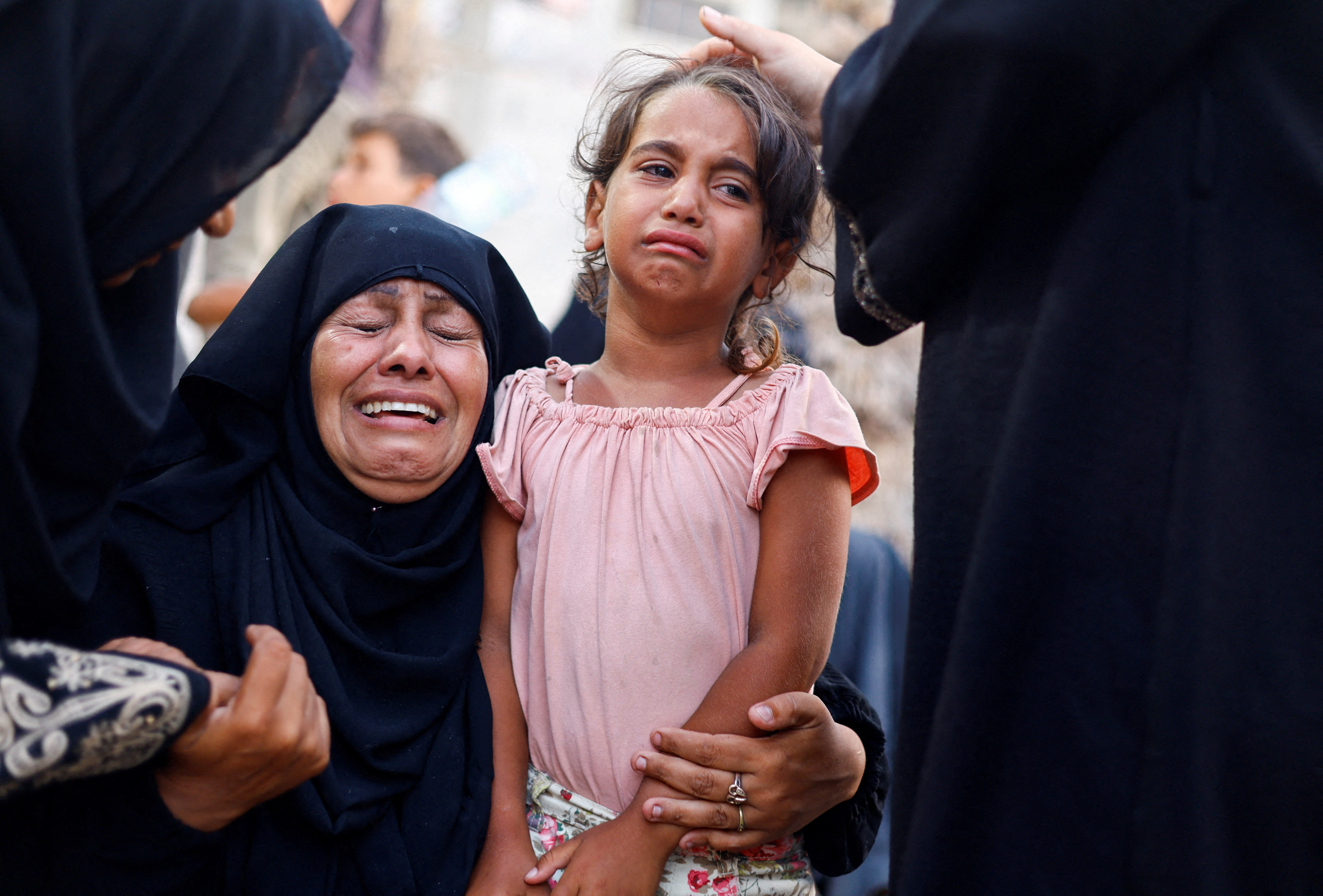A woman and a girl react following an Israeli strike that hit a tent camp, in Al-Mawasi area