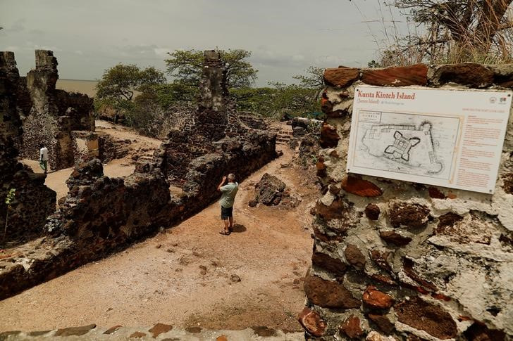 Tourist takes a photograph of ruins on the Kunta Kinte island in the Gambia River, Jufureh near Albreda