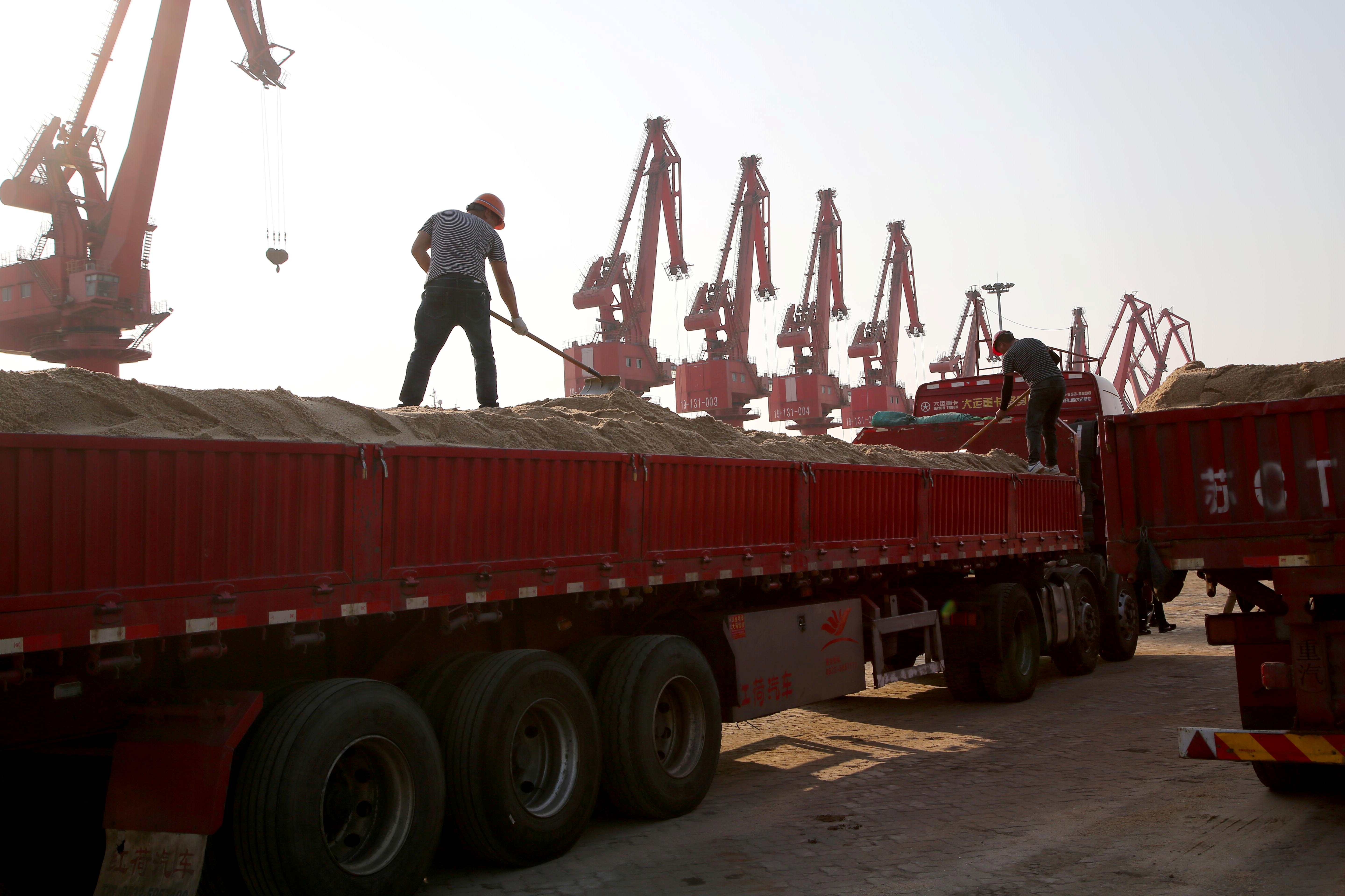 Men work on transporting nickel laterite ore on a truck at Ganyu port in Lianyungang