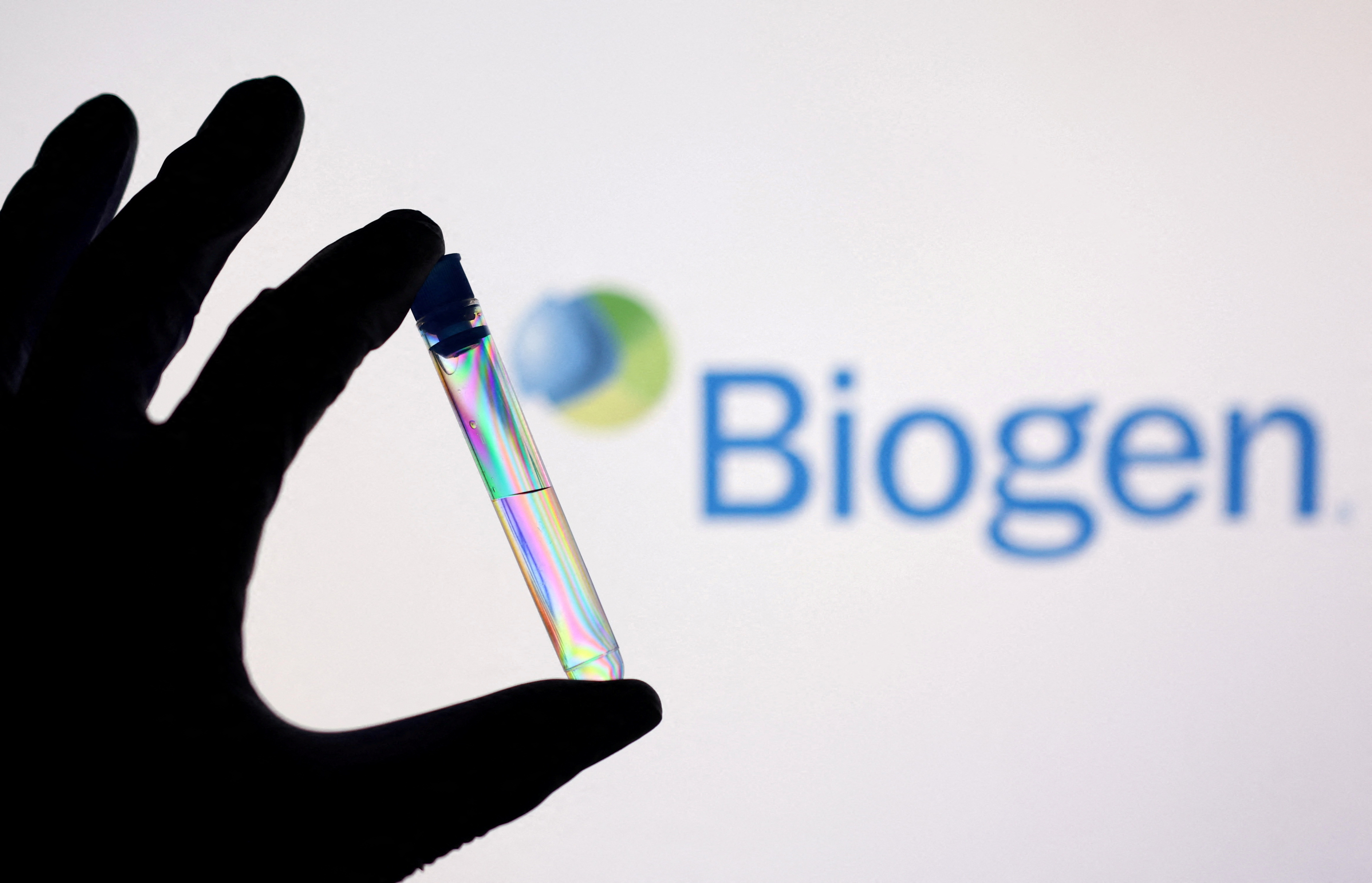 Illustration shows a test tube in front of displayed Biogen logo