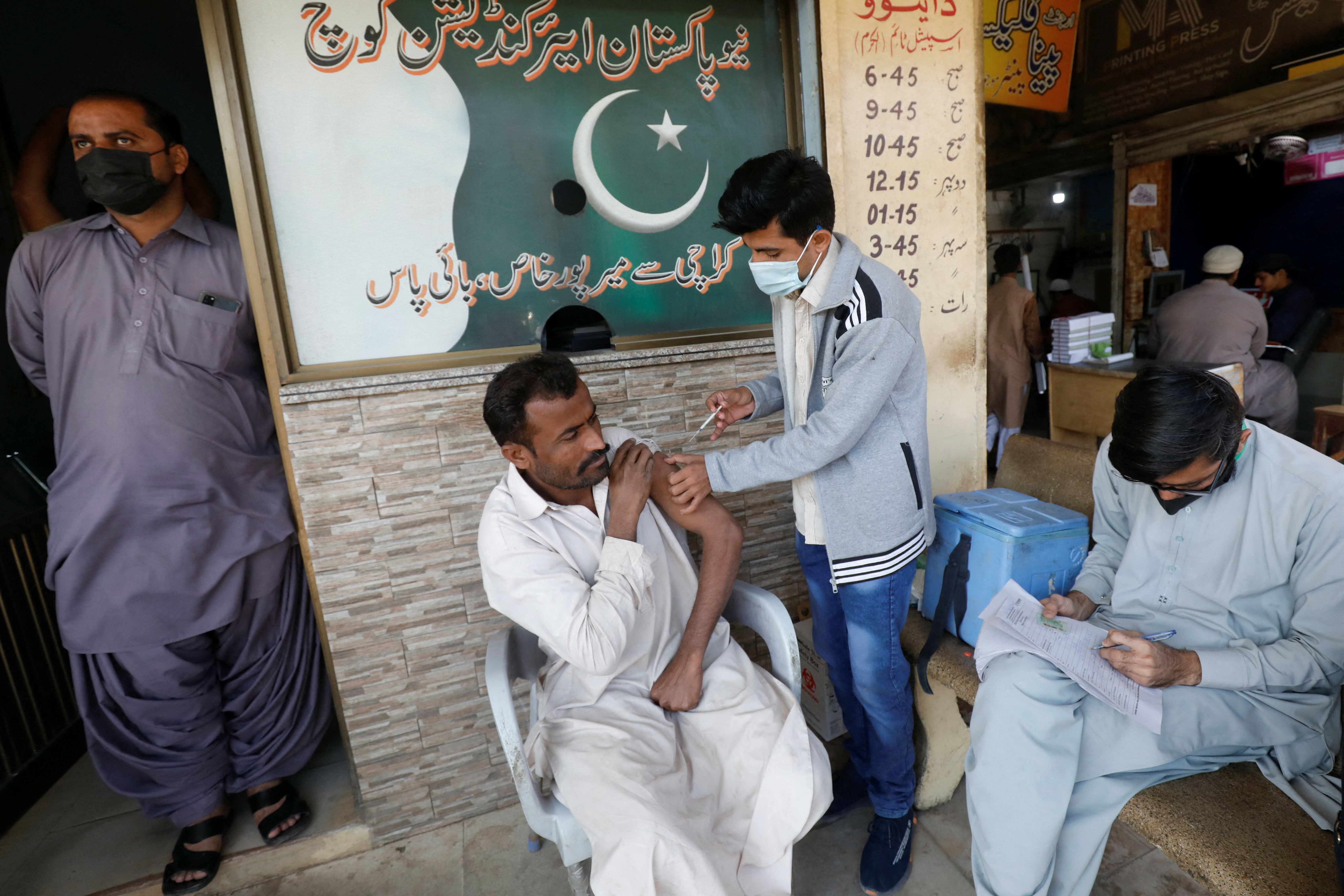 A man receives a dose of the COVID-19 vaccine at a market in Karachi