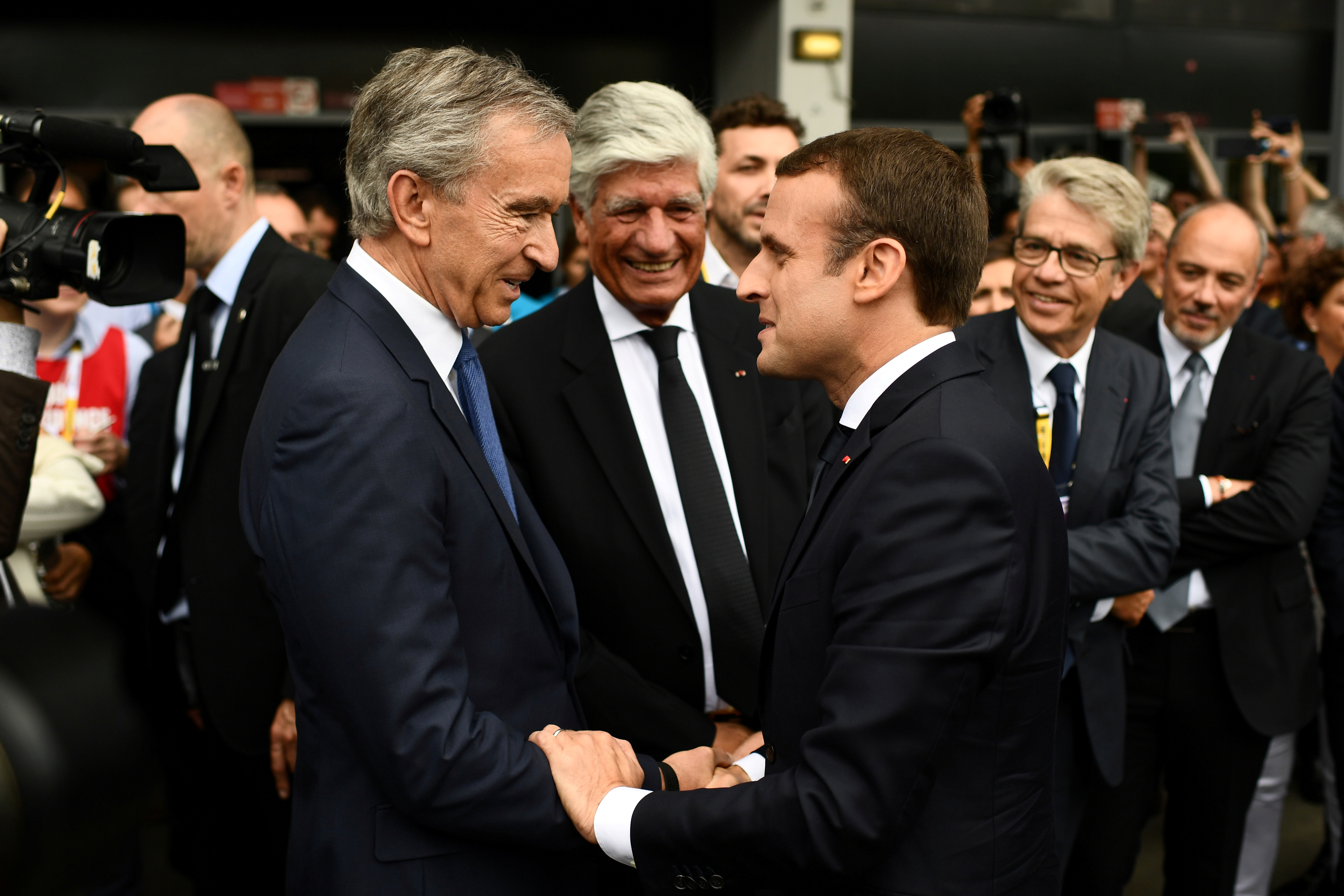 French President Emmanuel Macron shakes hands with LVMH Group CEO Bernard Arnault in Paris