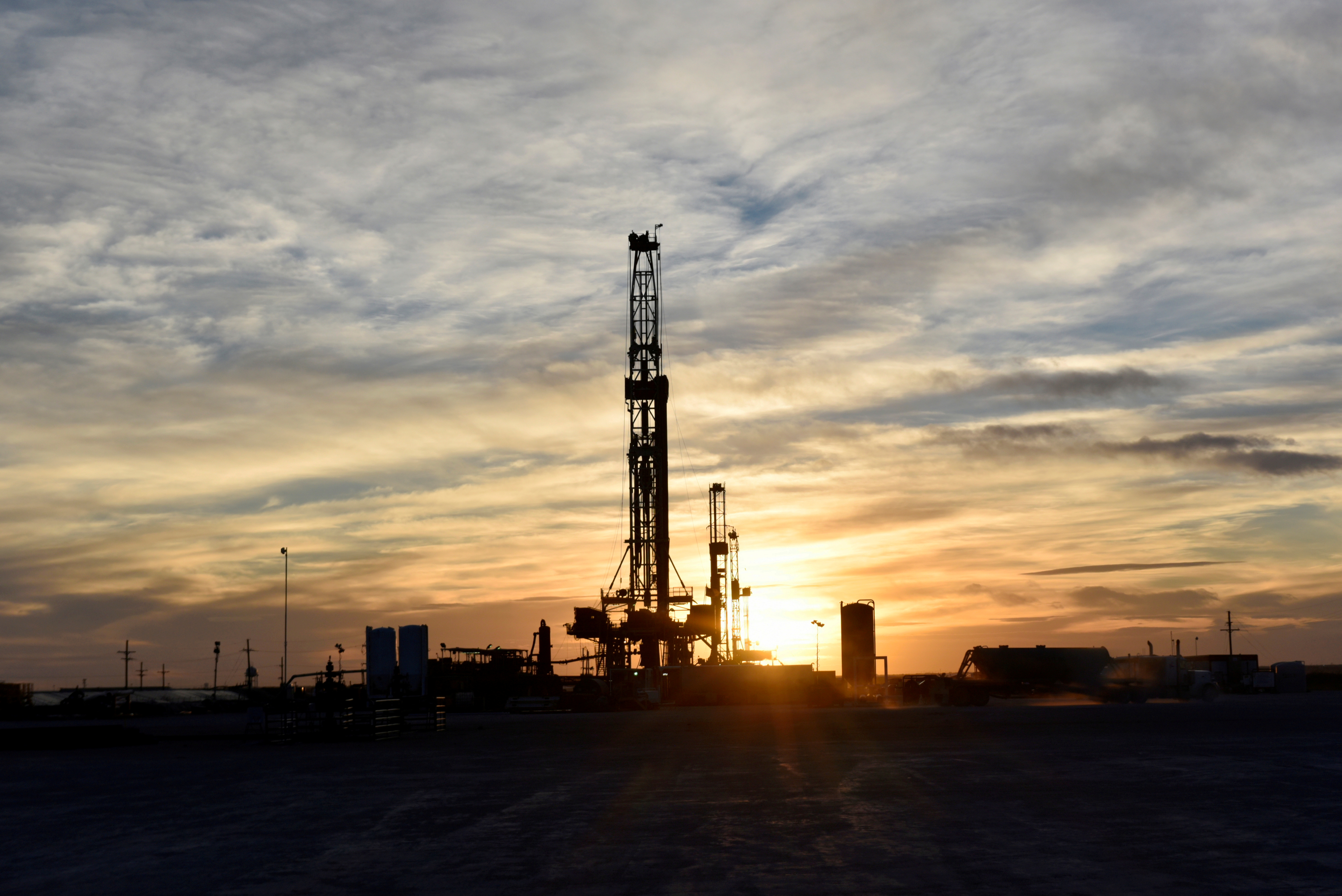 Drilling rigs operate at sunset in Midland