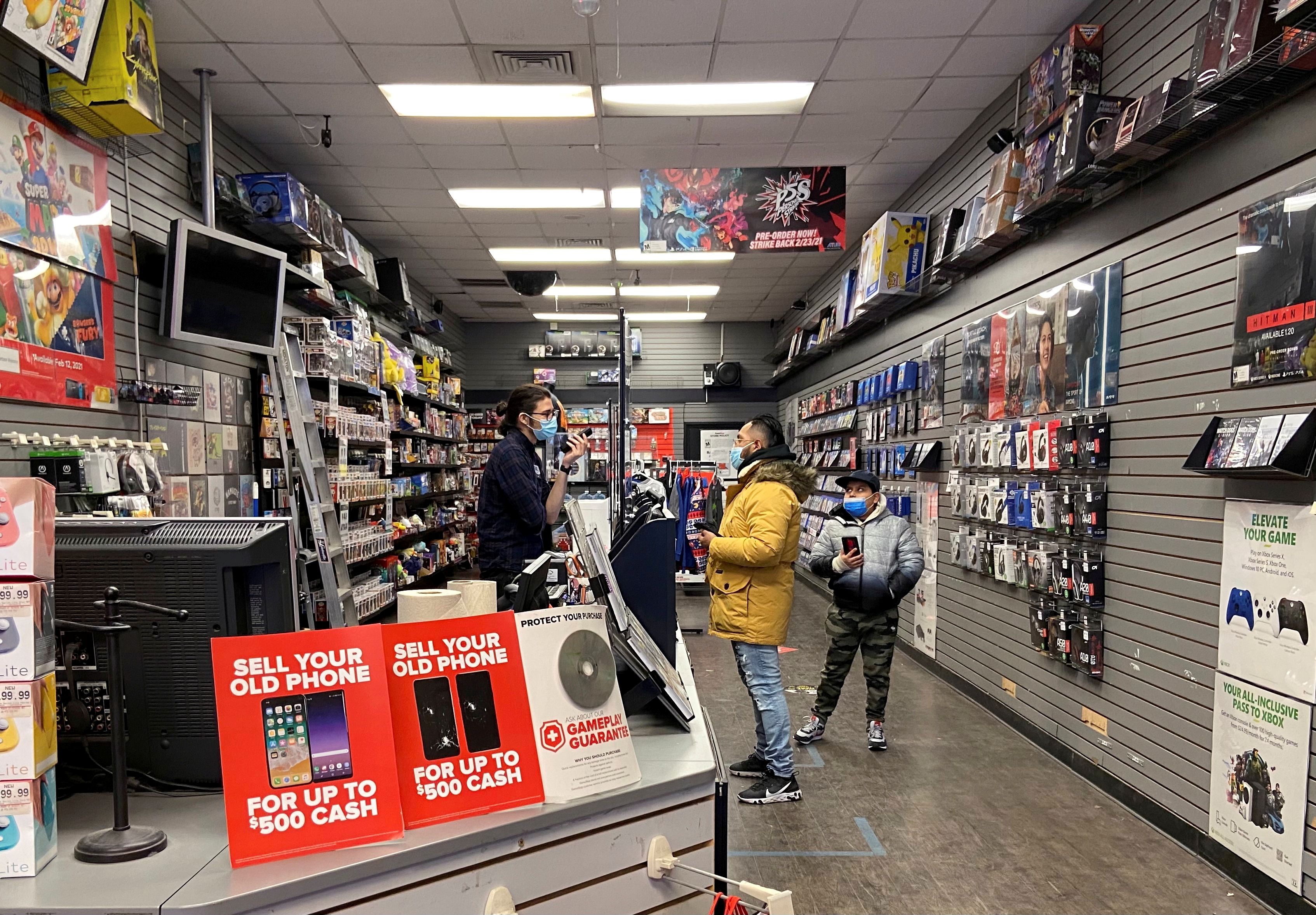 An employee talks with a customer at a GameStop shop in New York City