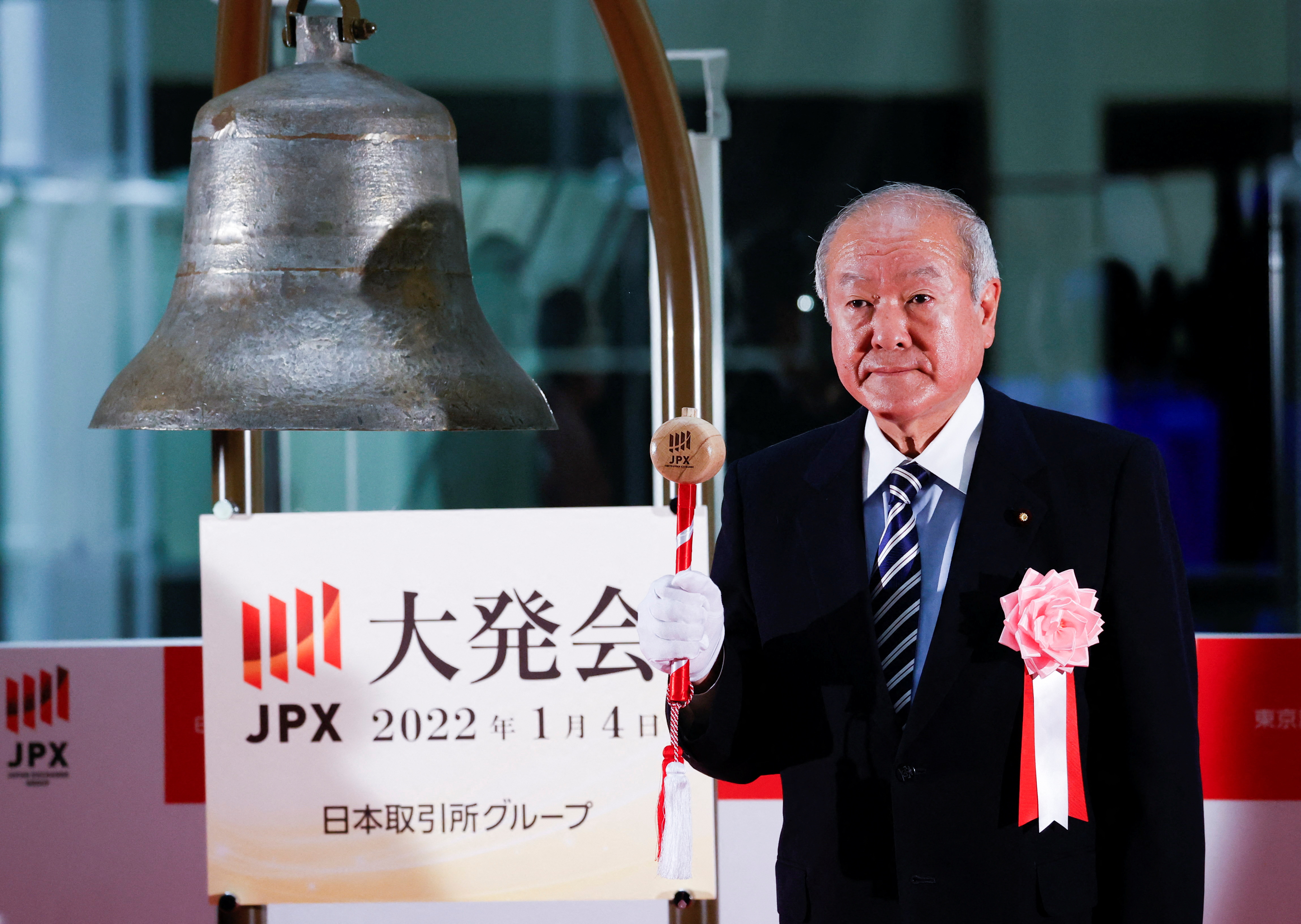 Japan's Finance Minister Shunichi Suzuki prepares to ring a bell during the New Year ceremony marking the open of trading in 2022 at the Tokyo Stock Exchange in Tokyo