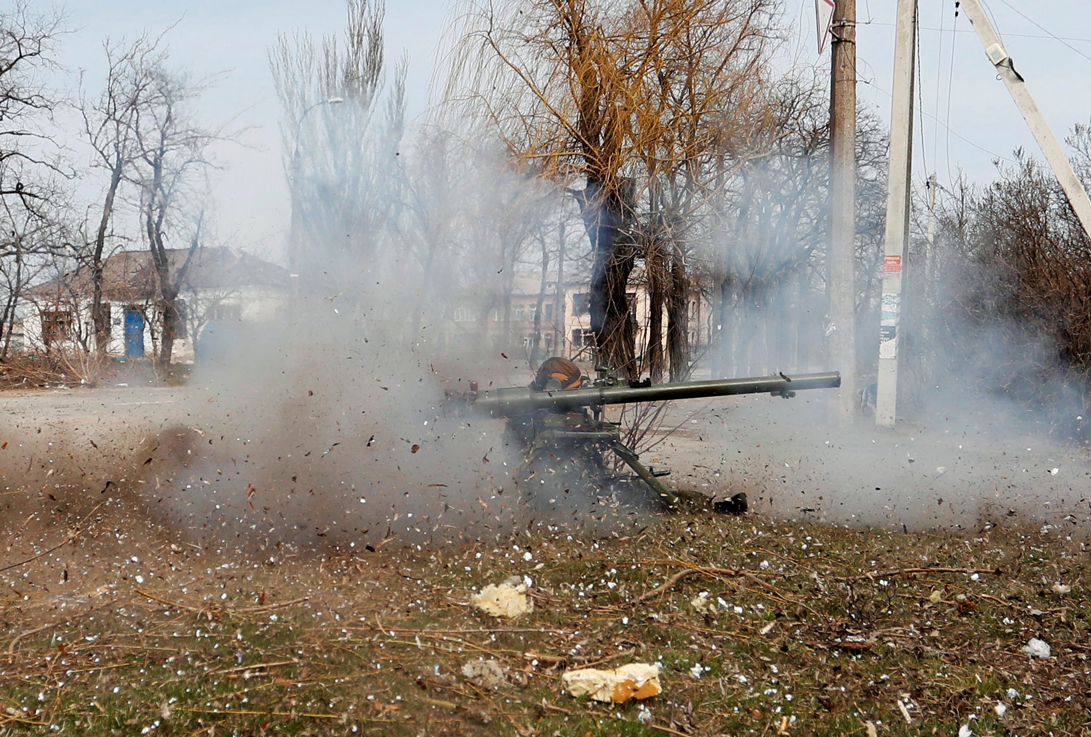 Service members of pro-Russian troops fire an anti-tank grenade launcher in Mariupol