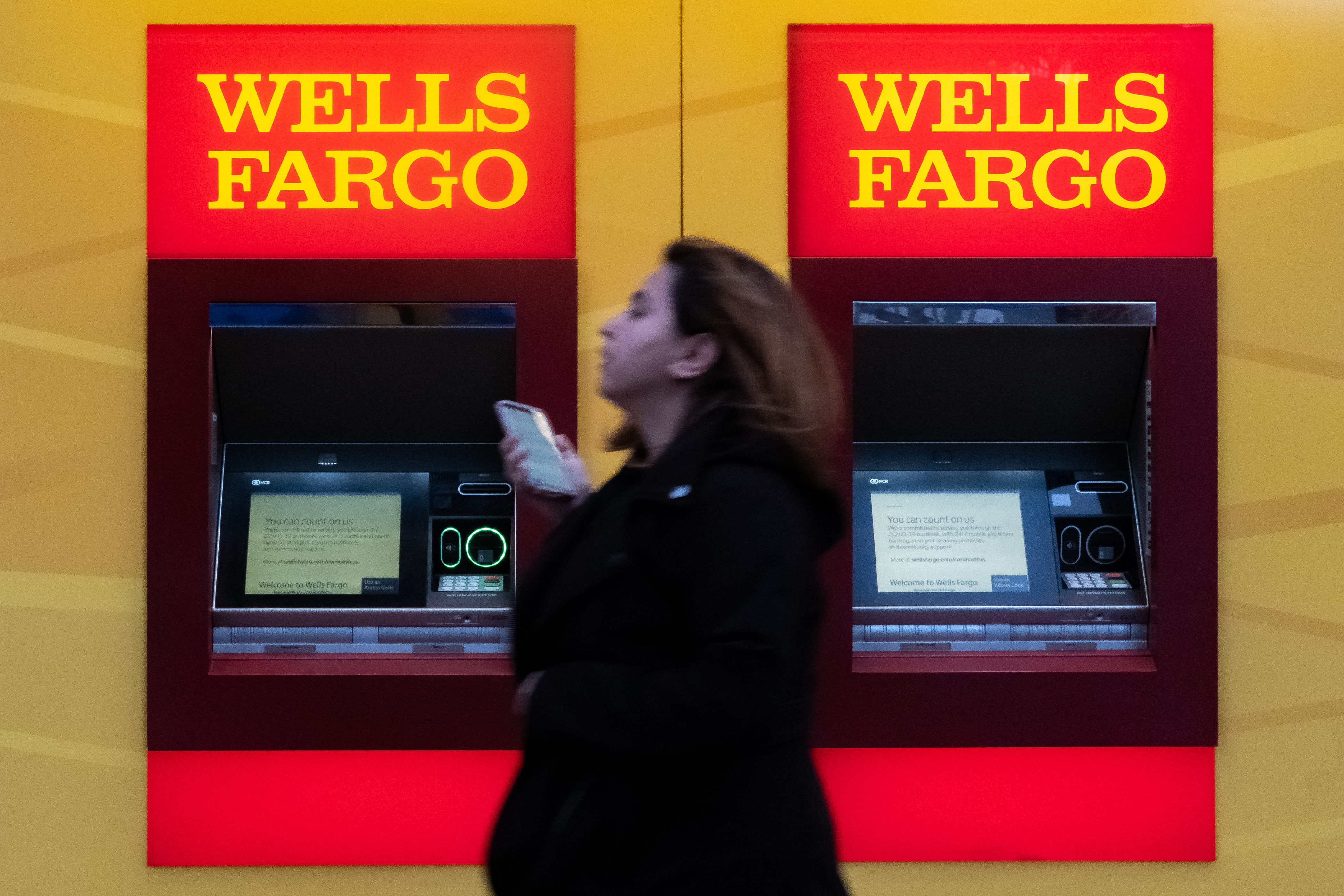 A woman walks past Wells Fargo bank in New York City