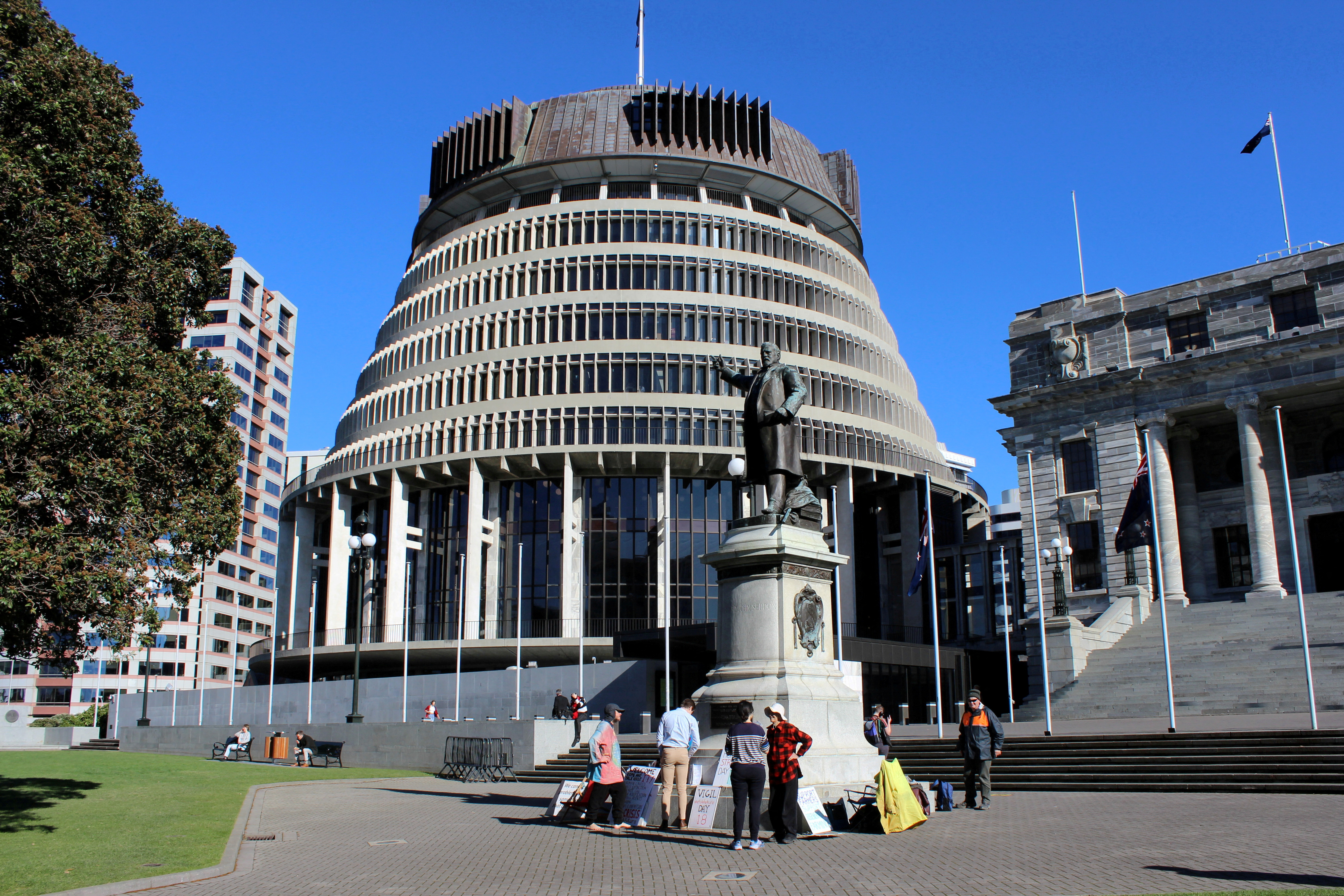People stand outside the executive wing of the New Zealand Parliament complex, popularly known as 