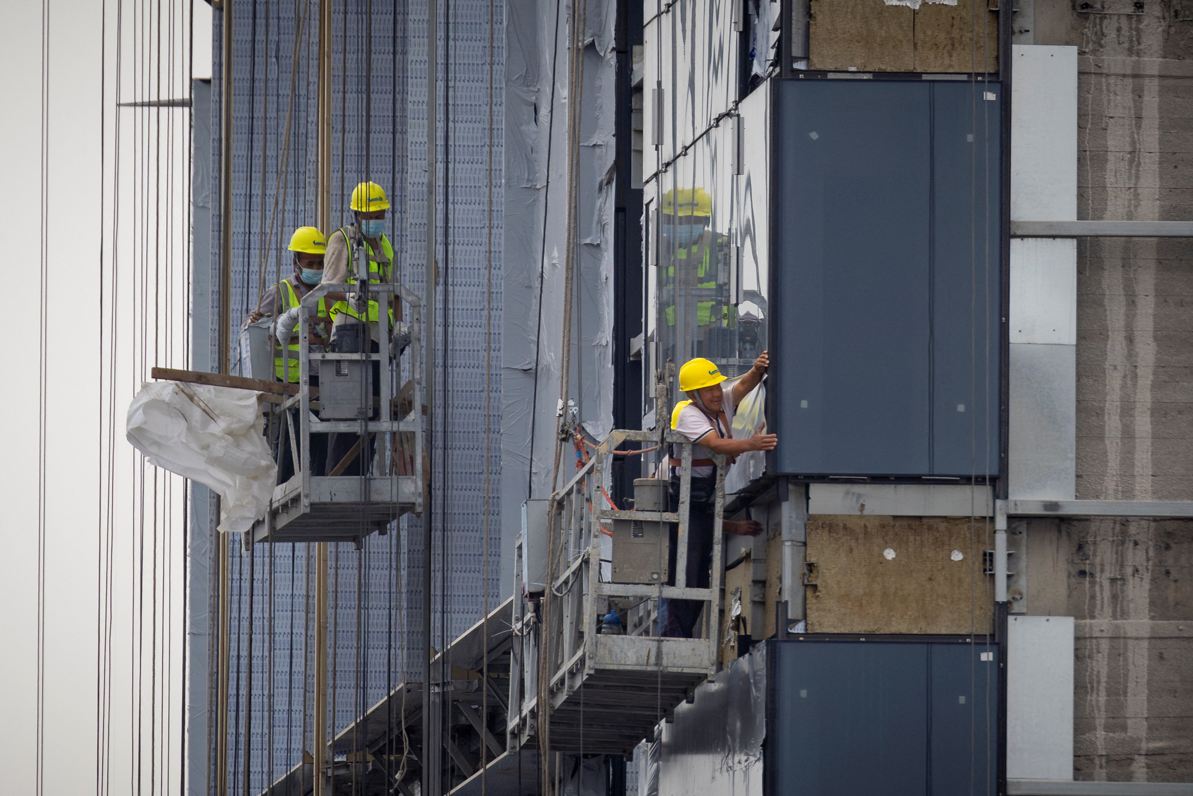 Những người đàn ông làm việc tại công trường xây dựng một tòa nhà chung cư ở Bắc Kinh