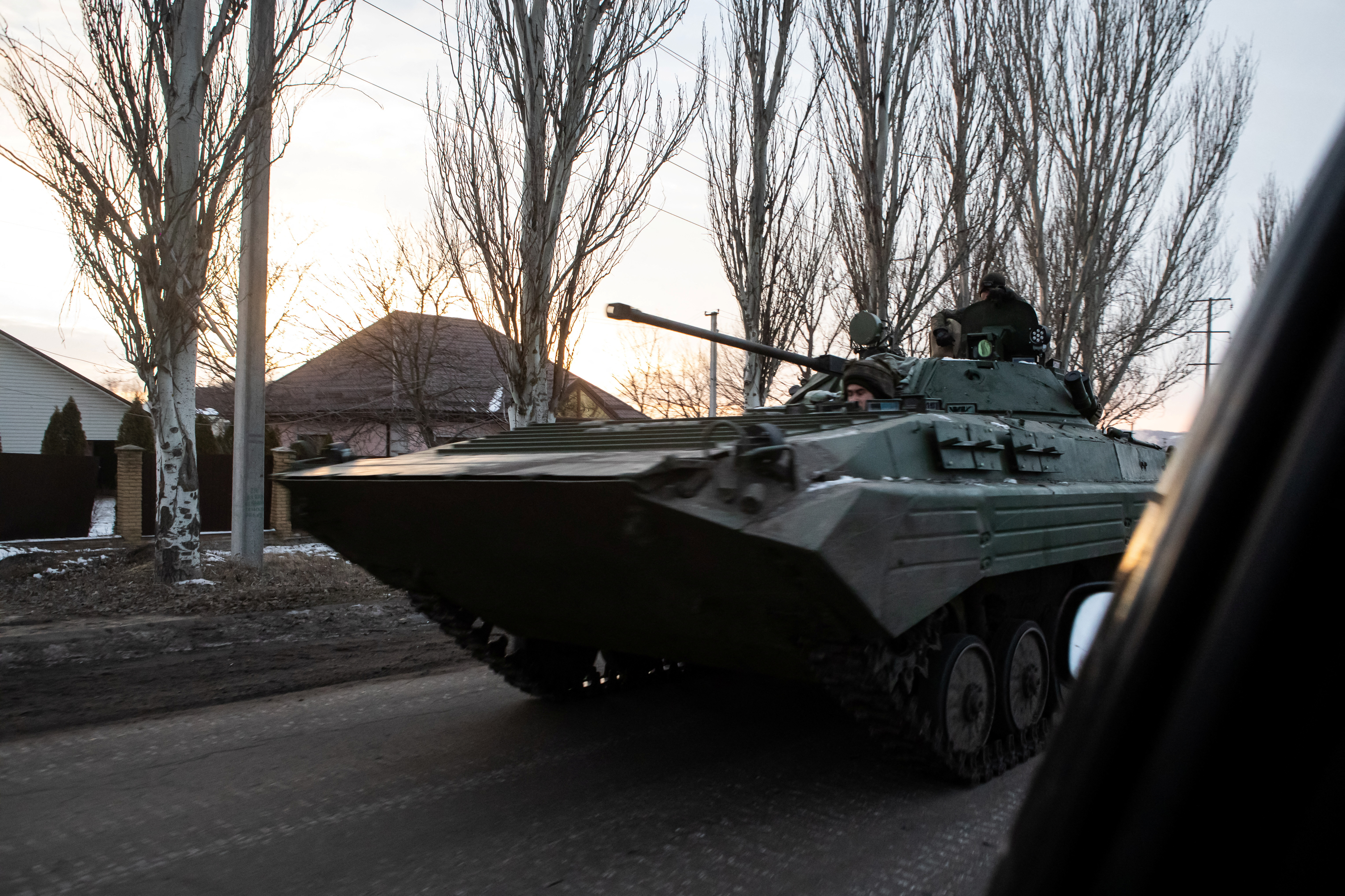 Ukrainian servicemen drive along a street with BMP-2 infantry fighting vehicle in the frontline town of Bakhmut