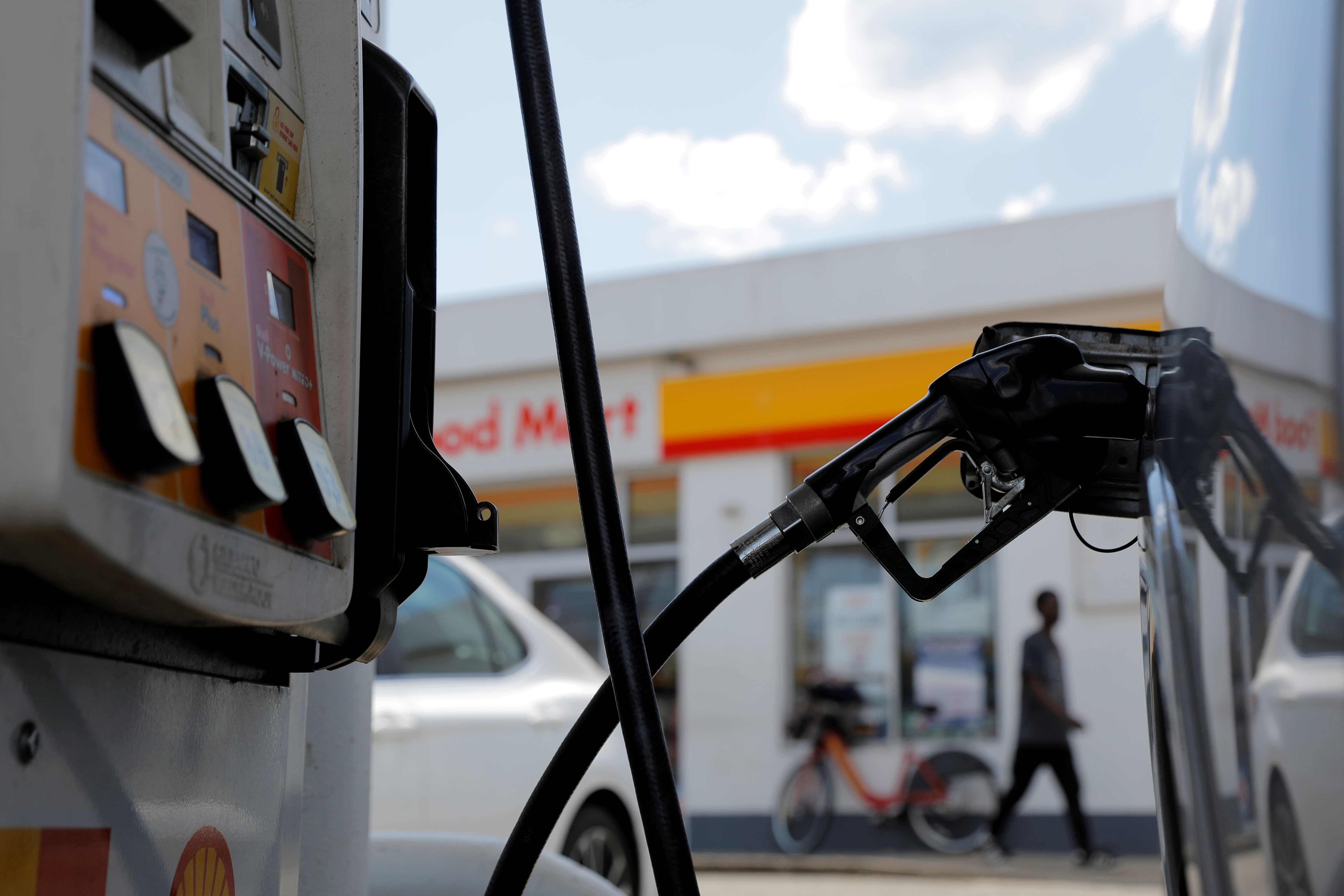 A gas pump is seen in a car at a Shell gas station in Washington, D.C., U.S., May 15, 2021. REUTERS/Andrew Kelly/File Photo