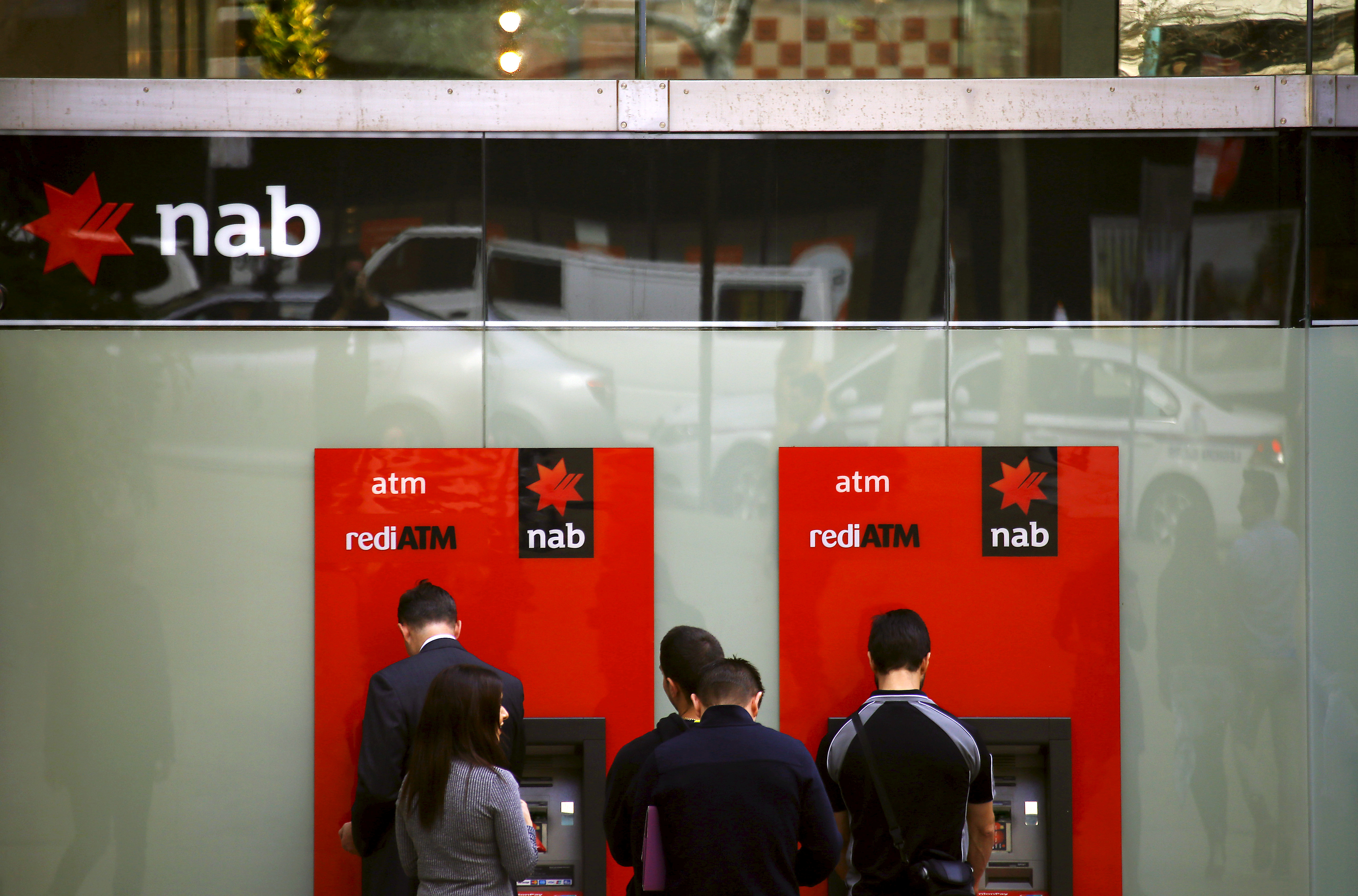 File photo of customers withdrawing money from National Australia Bank ATMs in central Sydney, Australia