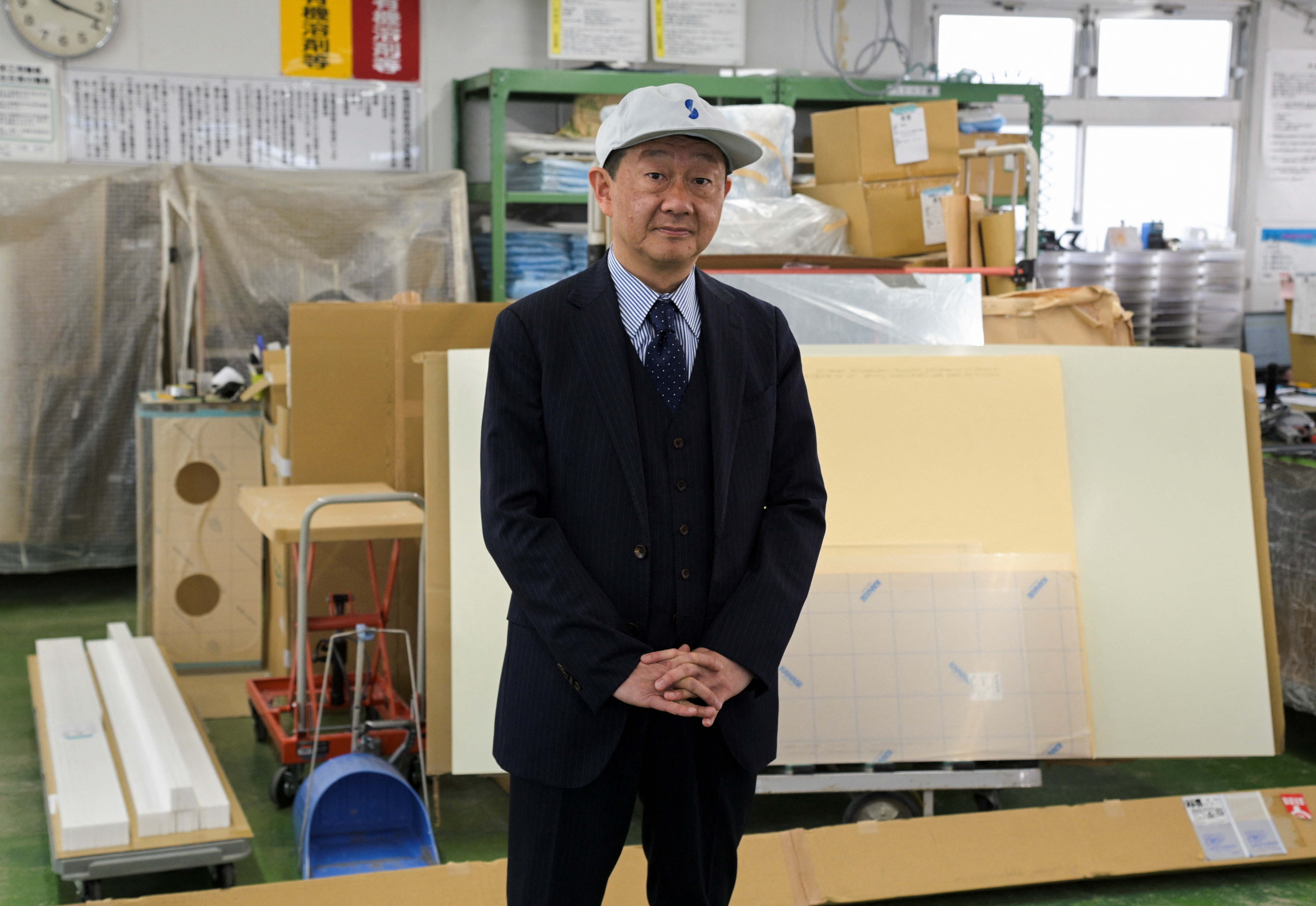 Satoaki Kanoh poses for a photograph at his company's factory in Tokyo