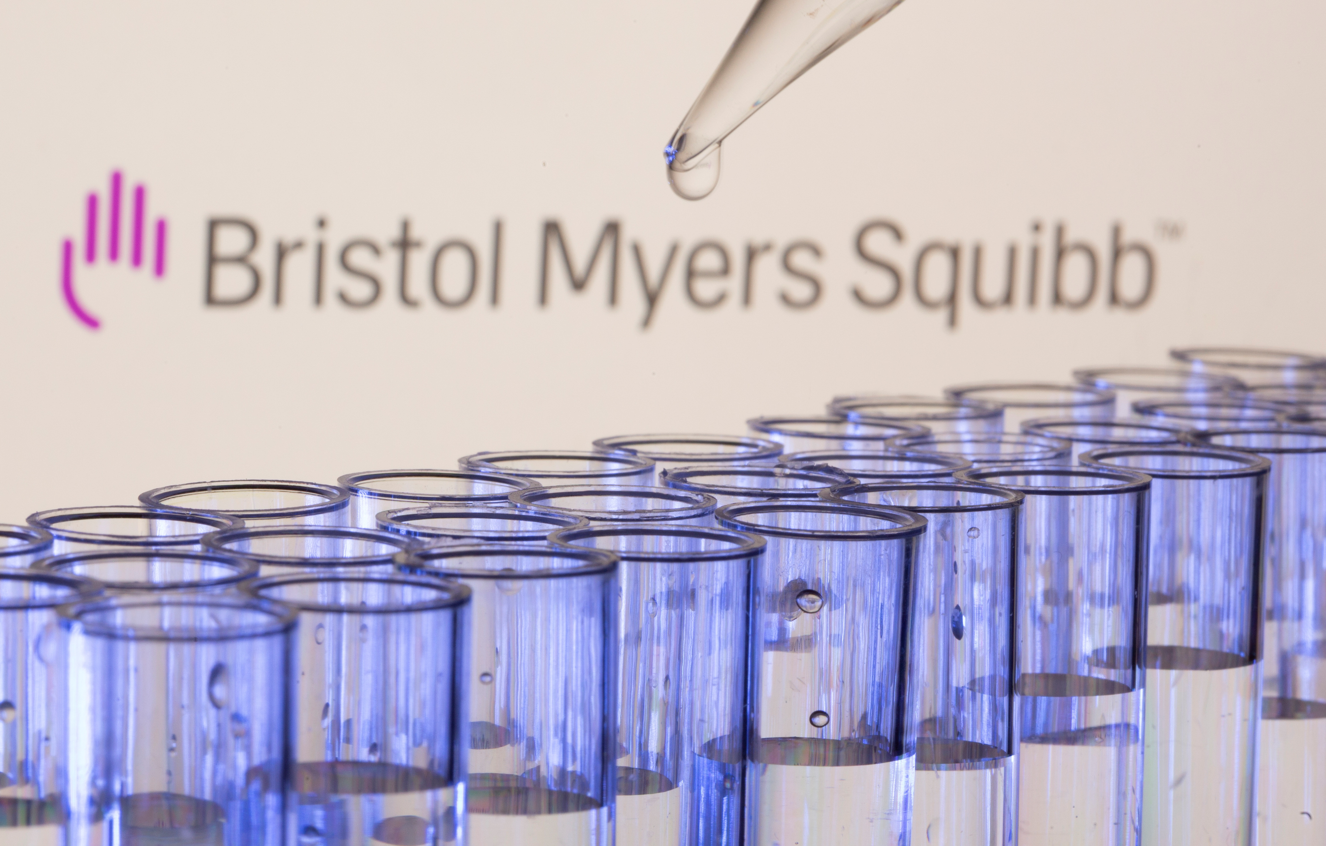 Test tubes are seen in front of a displayed Bristol Myers Squibb logo in this illustration