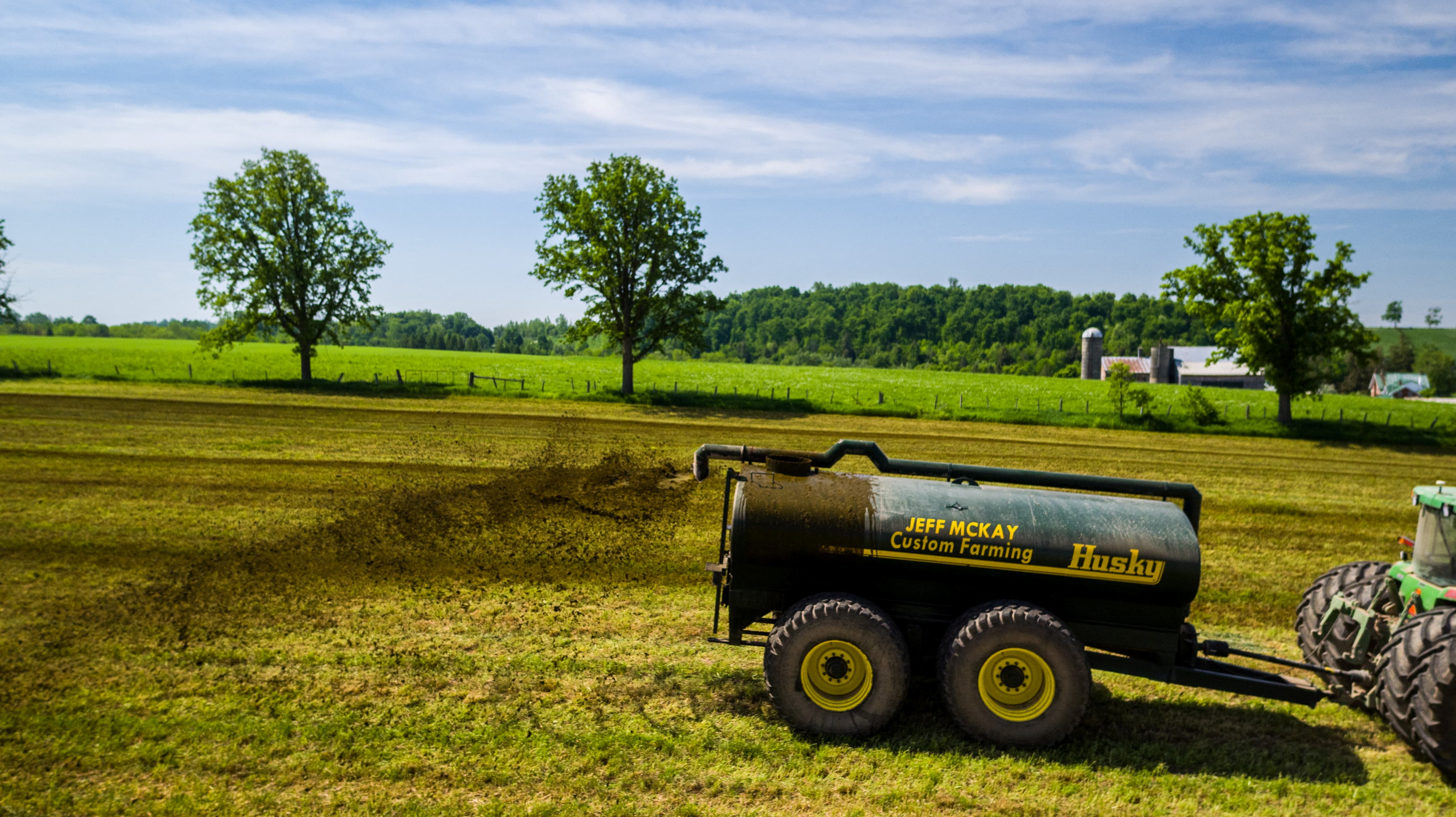 A custom hauler spreads dairy manure on hay ground on a farm in Wallenstein, Ontario