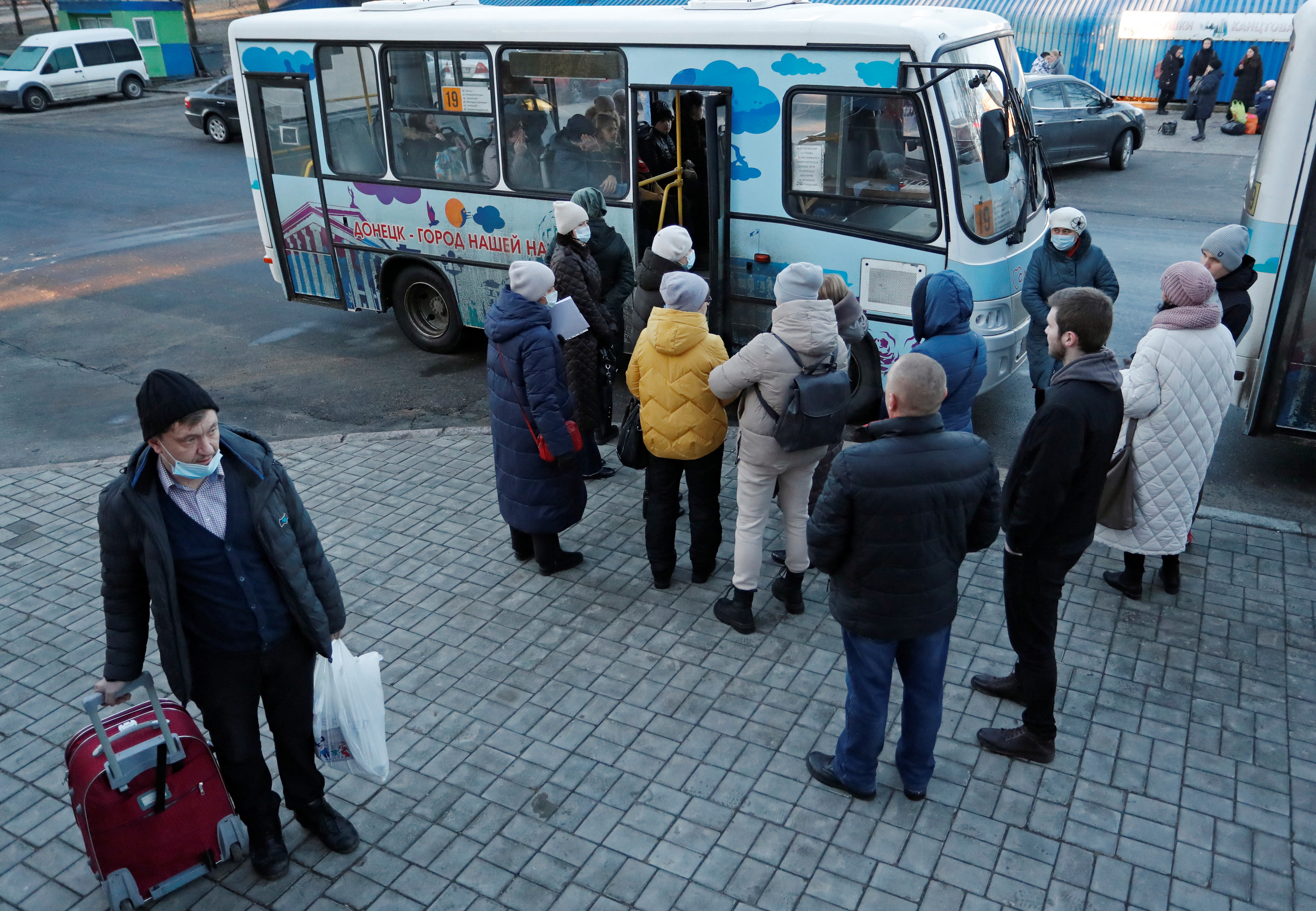 People board a bus during the evacuation of local residents to Russia, in Donetsk
