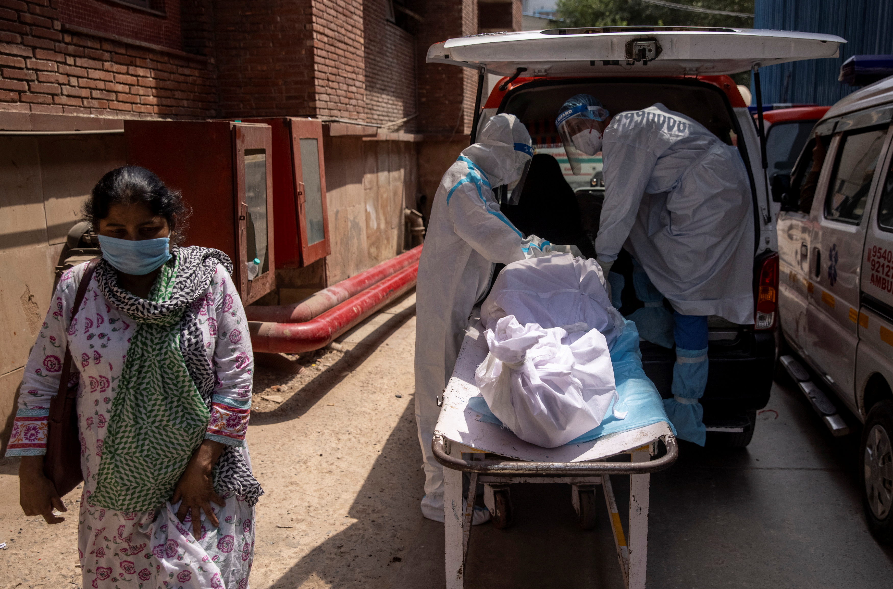 Healthcare workers load the body of a man died from the coronavirus disease (COVID-19) into an ambulance, in Lok Nayak Jai Prakash (LNJP) hospital, amidst the spread of the disease in New Delhi