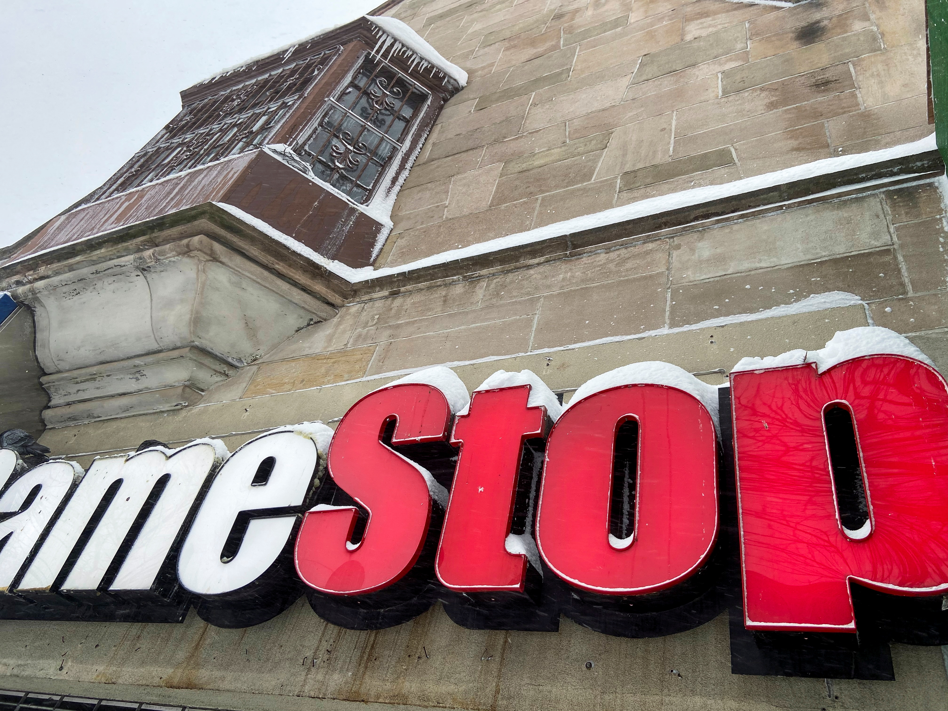 Snow settles on a GameStop sign in New York City