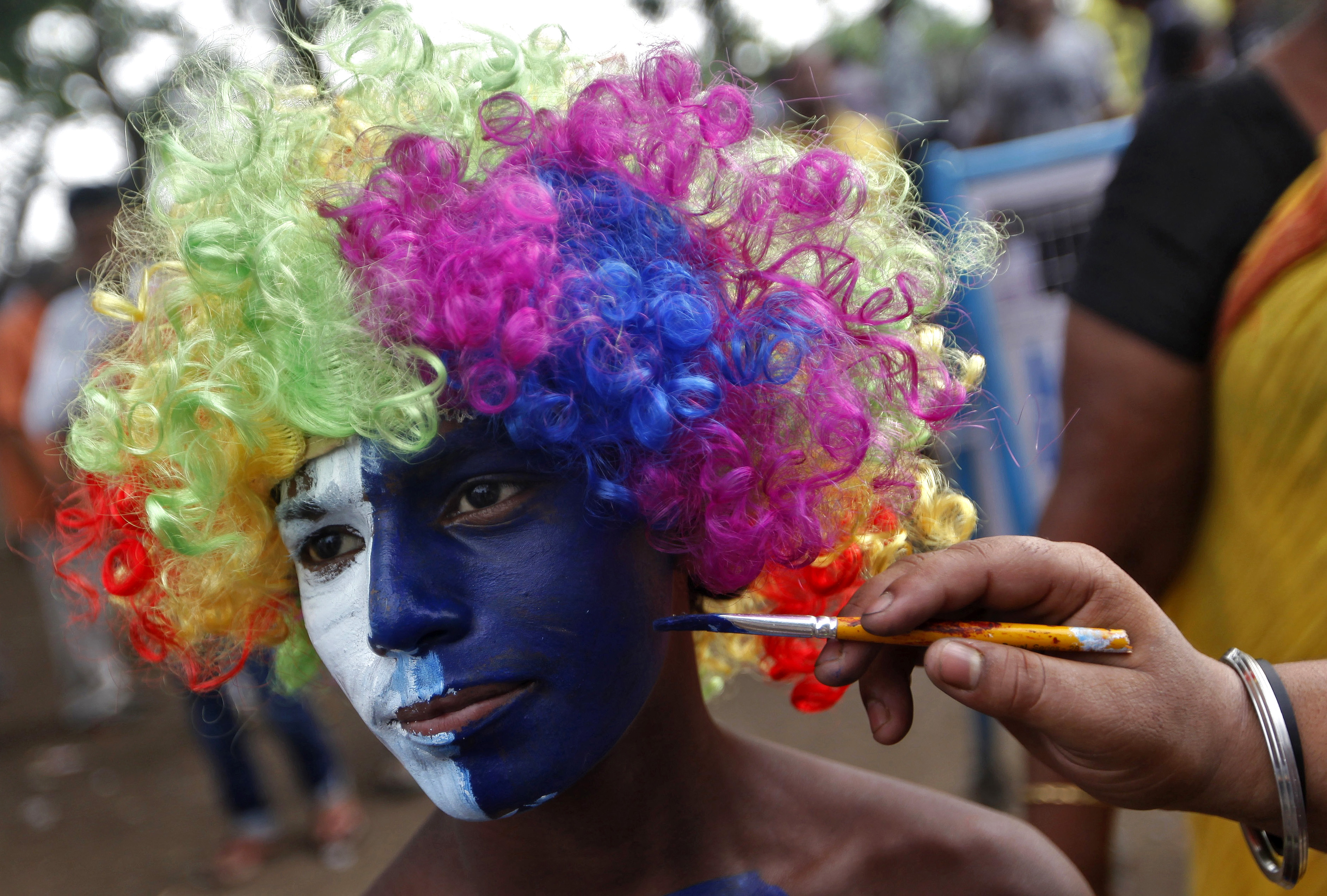 A cricket fan gets his face painted before the IPL qualifier 2 match outside a stadium in Kolkata