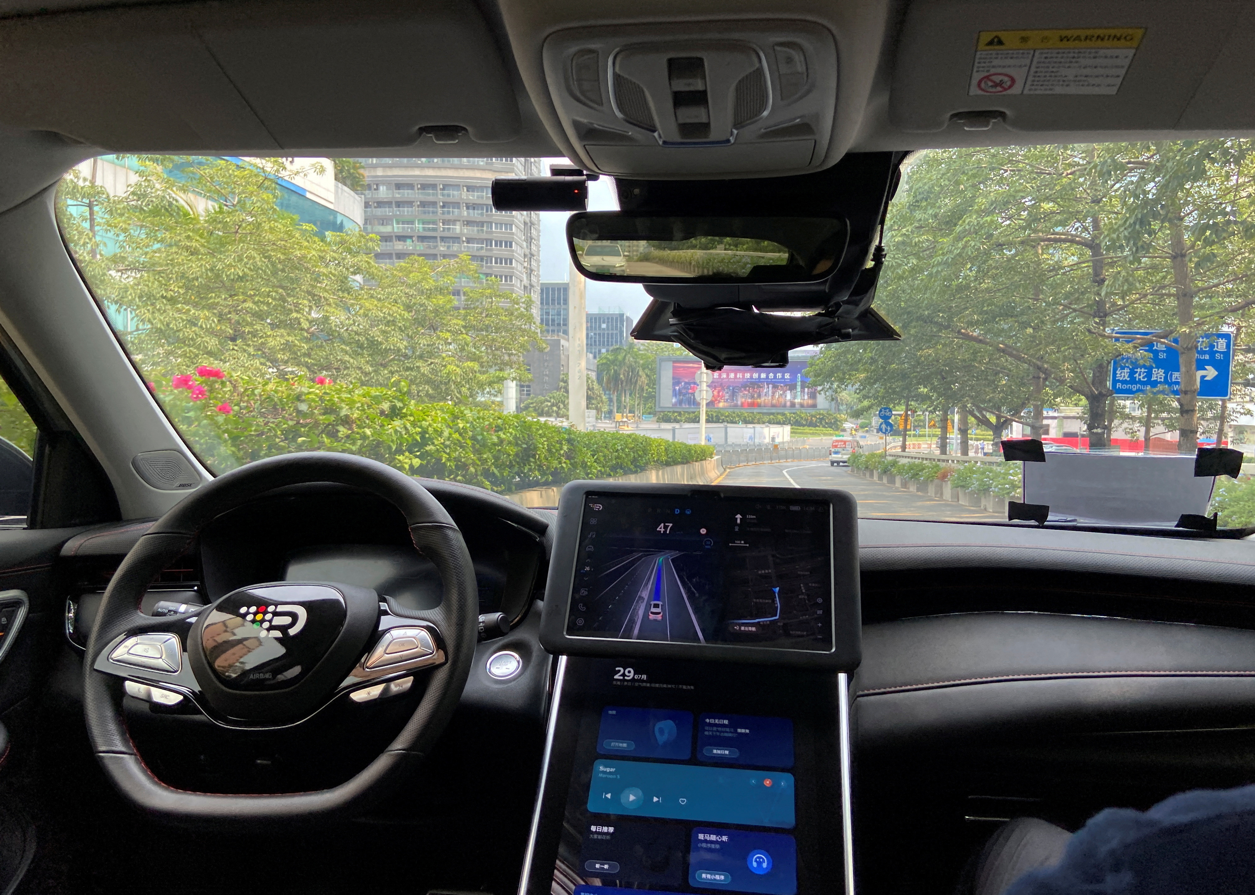 Safety driver sits on the passenger seat as the car with autonomous driving system by DeepRoute.ai, drives itself on a street in Shenzhen