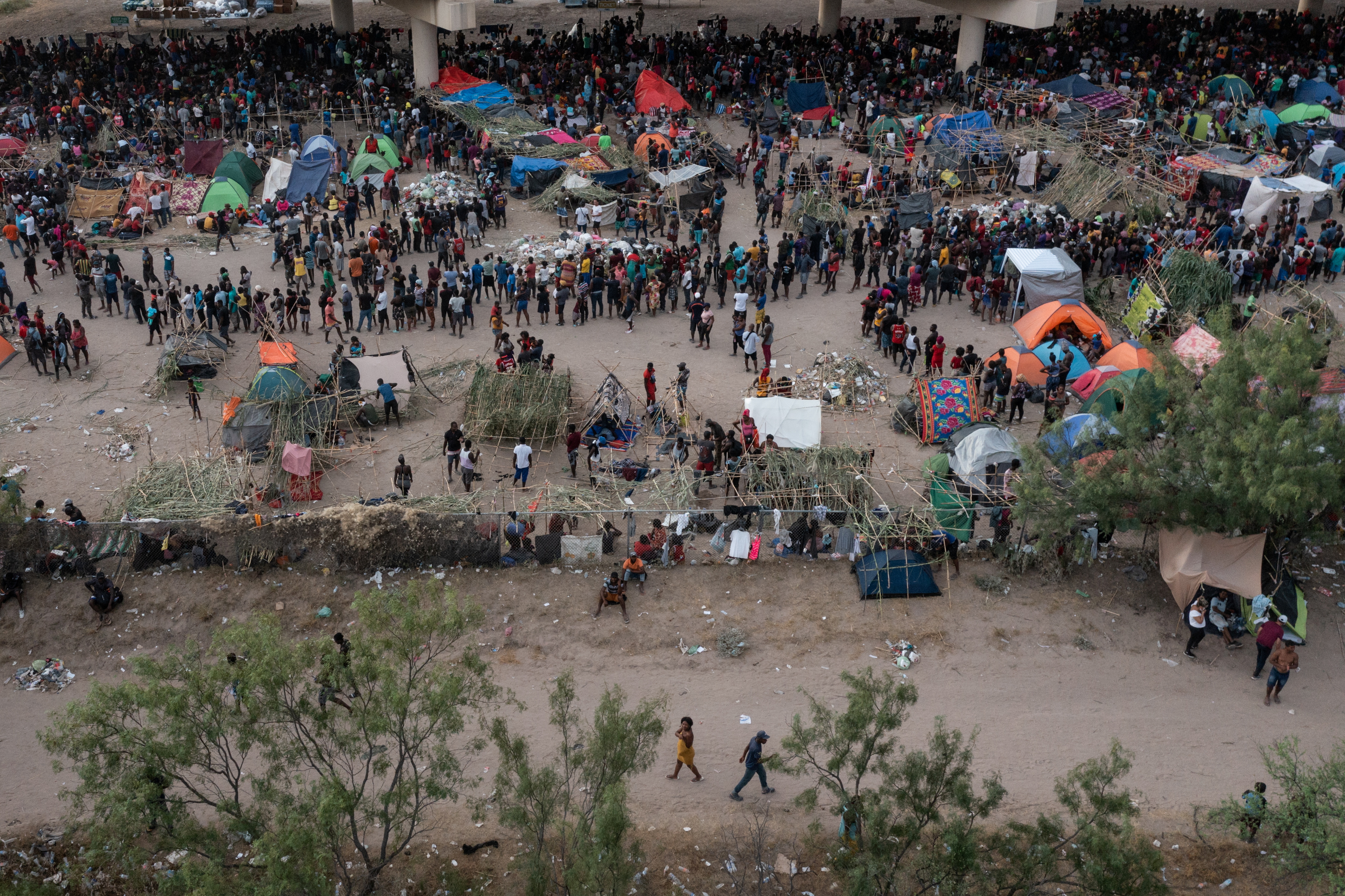 Some thousands of migrants take shelter as they await to be processed near the Del Rio International Bridge after crossing the Rio Grande river into the U.S. from Ciudad Acuna in Del Rio, Texas, U.S. September 18, 2021. Picture taken with a drone. REUTERS/Adrees Latif