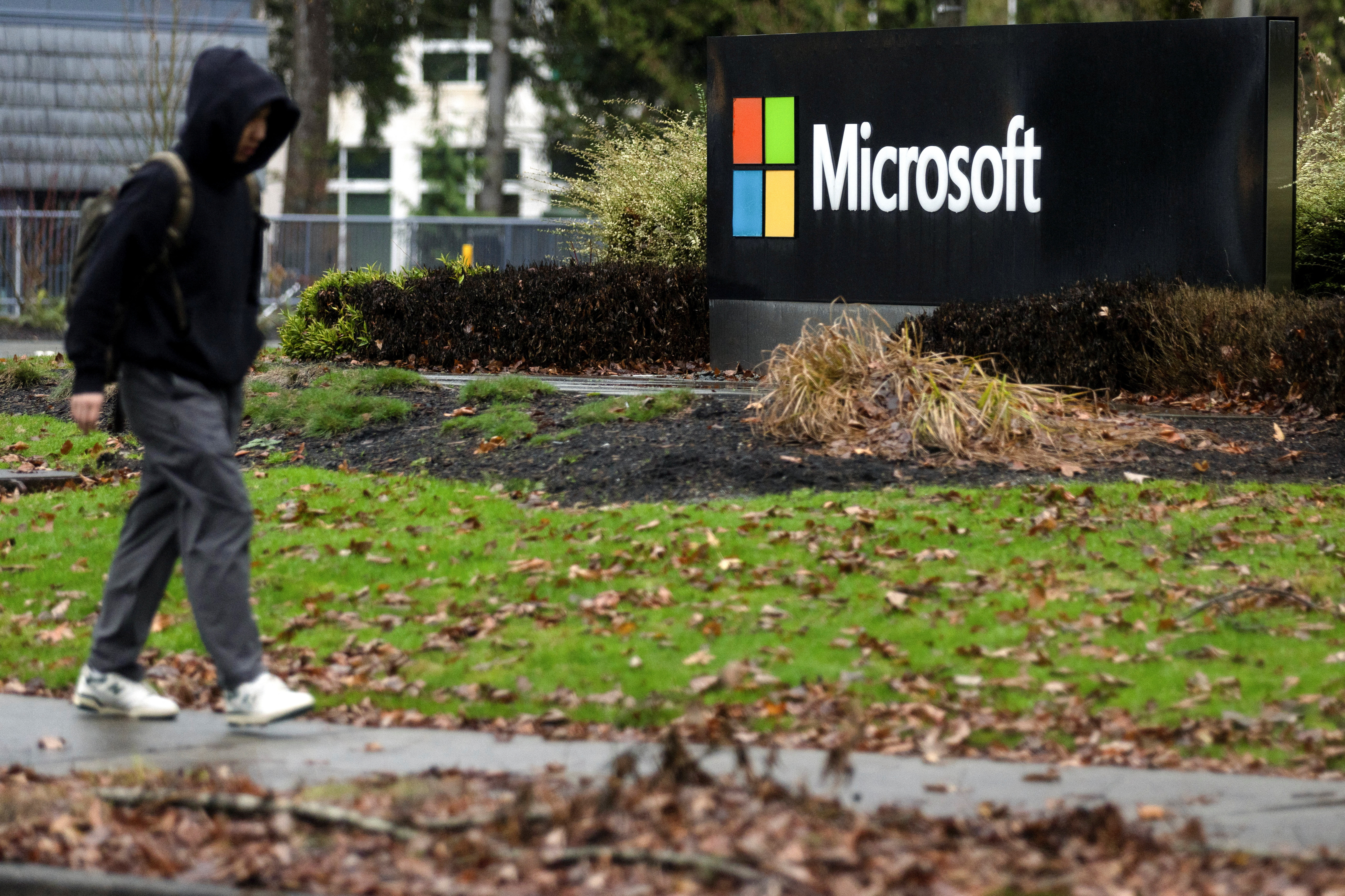 A person walks past Microsoft signage at the headquarters in Redmond