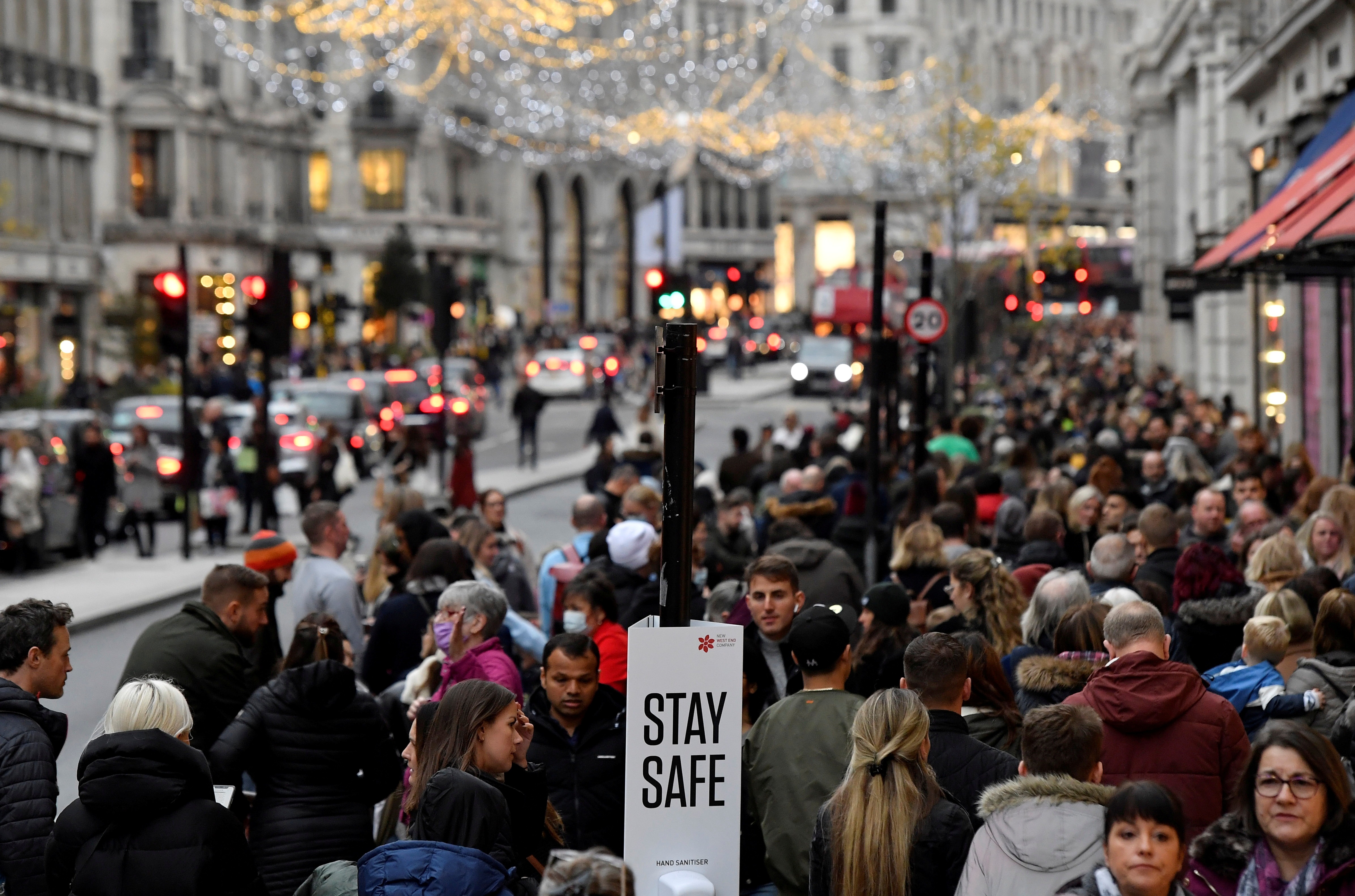 Shoppers walk past a message on a hand sanitiser station amid the spread of the coronavirus disease (COVID-19) pandemic, in Regent Street, London, Britain, November 20, 2021. REUTERS/Toby Melville