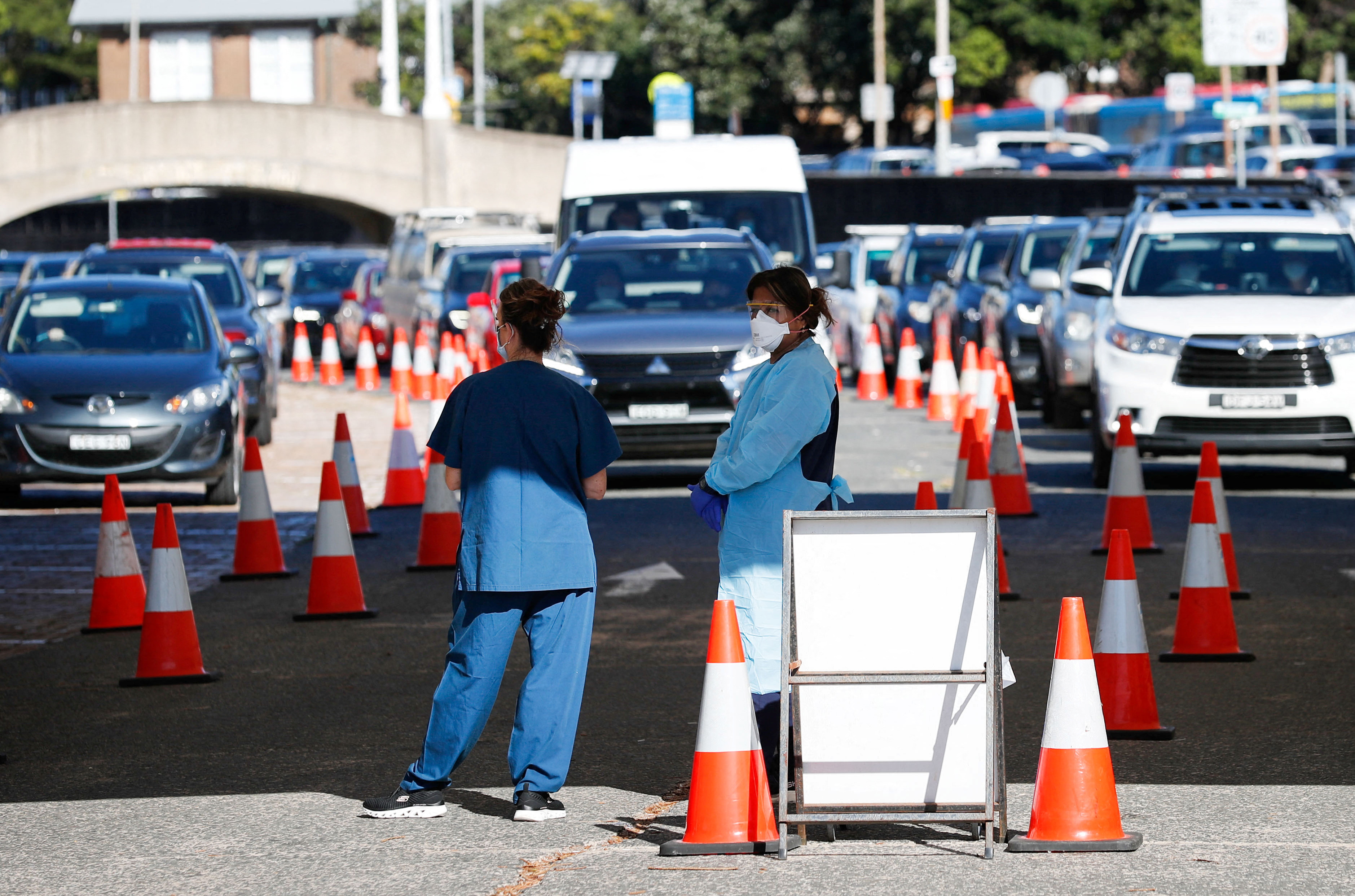 Healthcare workers wait for the next vehicle at a coronavirus disease (COVID-19) testing clinic as the Omicron coronavirus variant continues to spread in Sydney, Australia, December 30, 2021.  REUTERS/Nikki Short