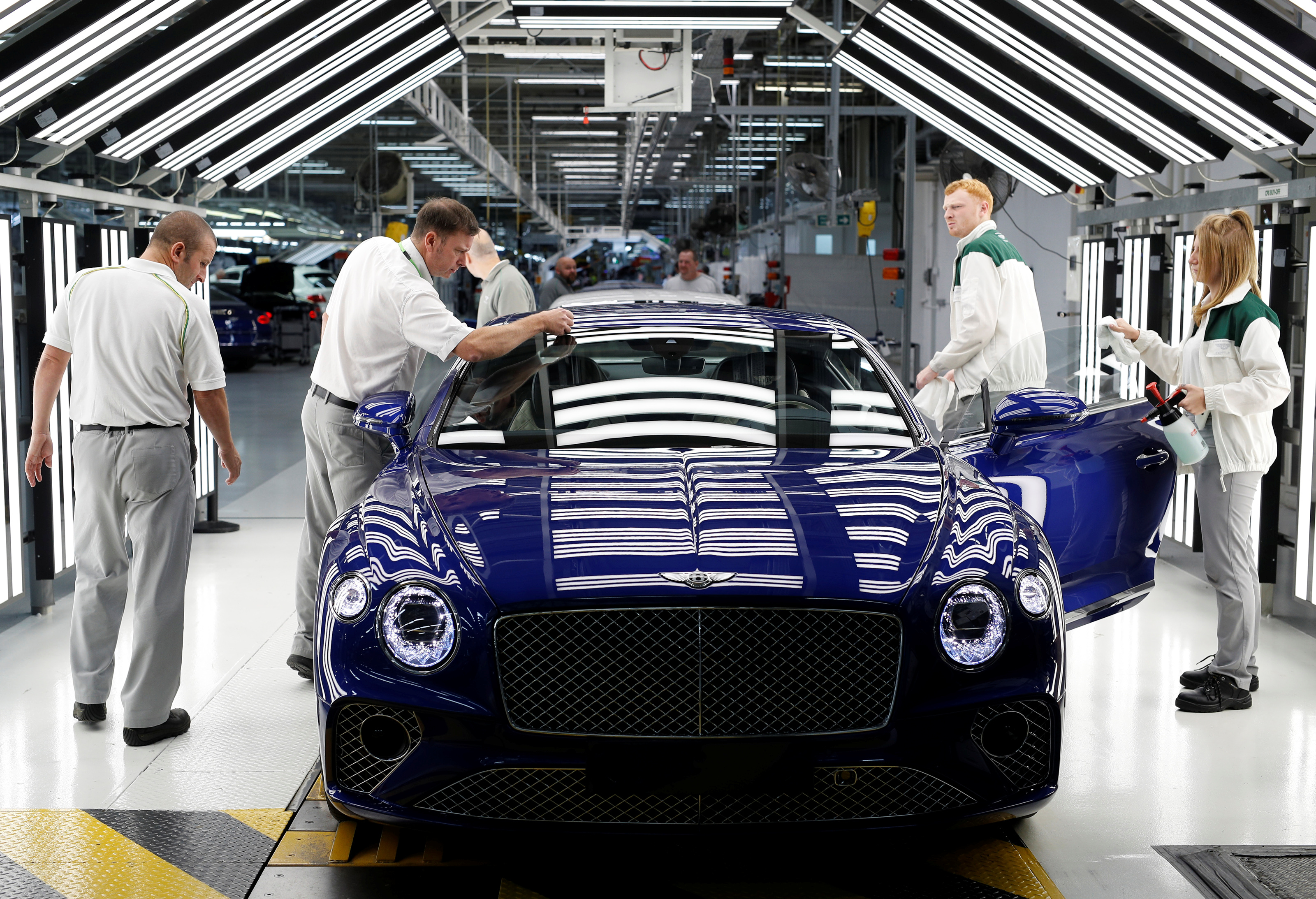 Workers inspect a Bentley Continental GT at the luxury automaker's manufacturing facility in Crewe