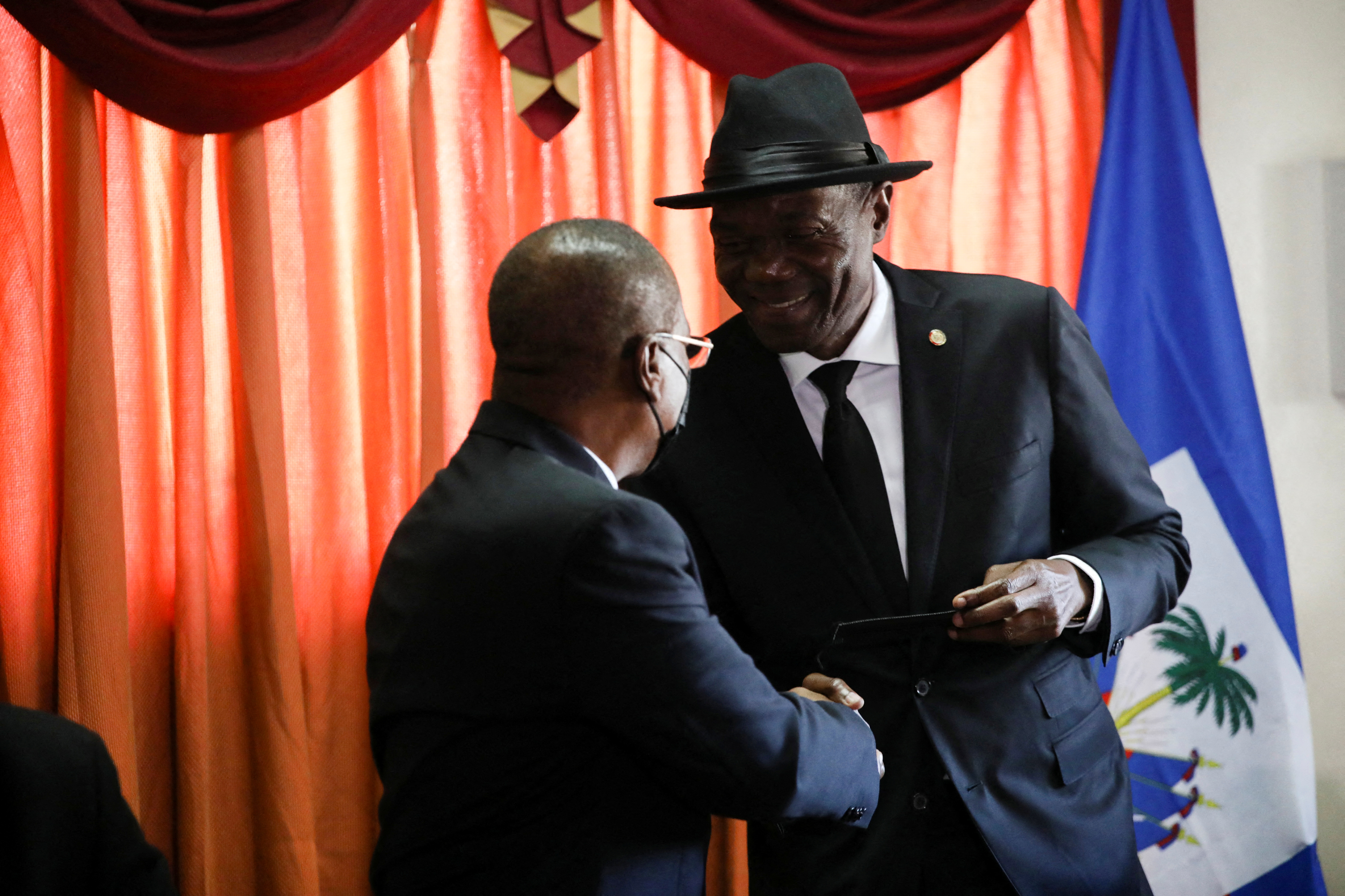 Haiti's outgoing Senate leader Joseph Lambert shakes hands with Senator Pierre Francois Syldor at a news conference where Lambert announced his intention to continue holding sessions as his term expires, in Port-au-Prince, Haiti January 10, 2022. REUTERS/Ralph Tedy Erol
