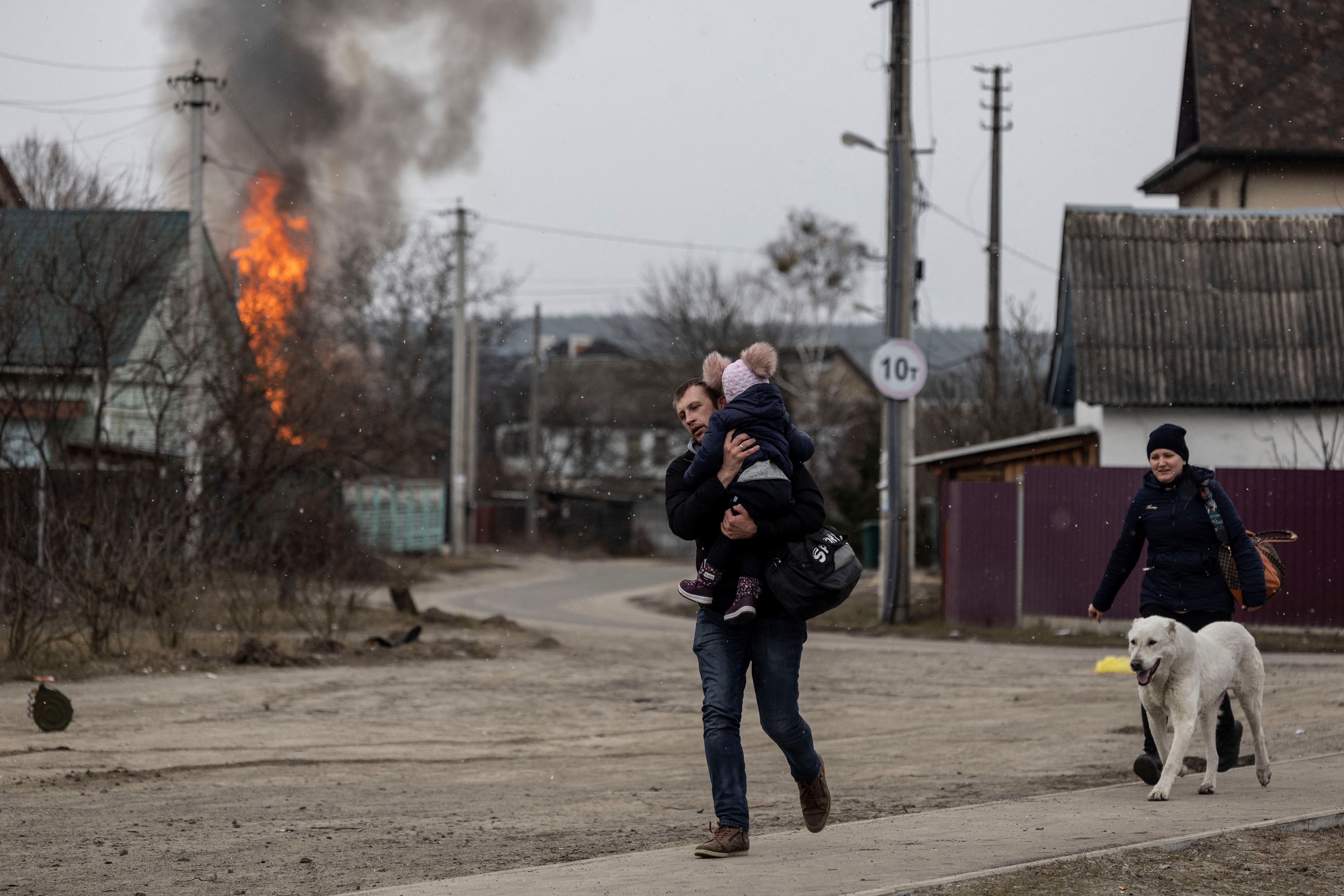 Local residents escape from the town of Irpin, after heavy shelling landed on the only escape route used by locals, as Russian troops advance towards the capital of Kyiv, in Irpin