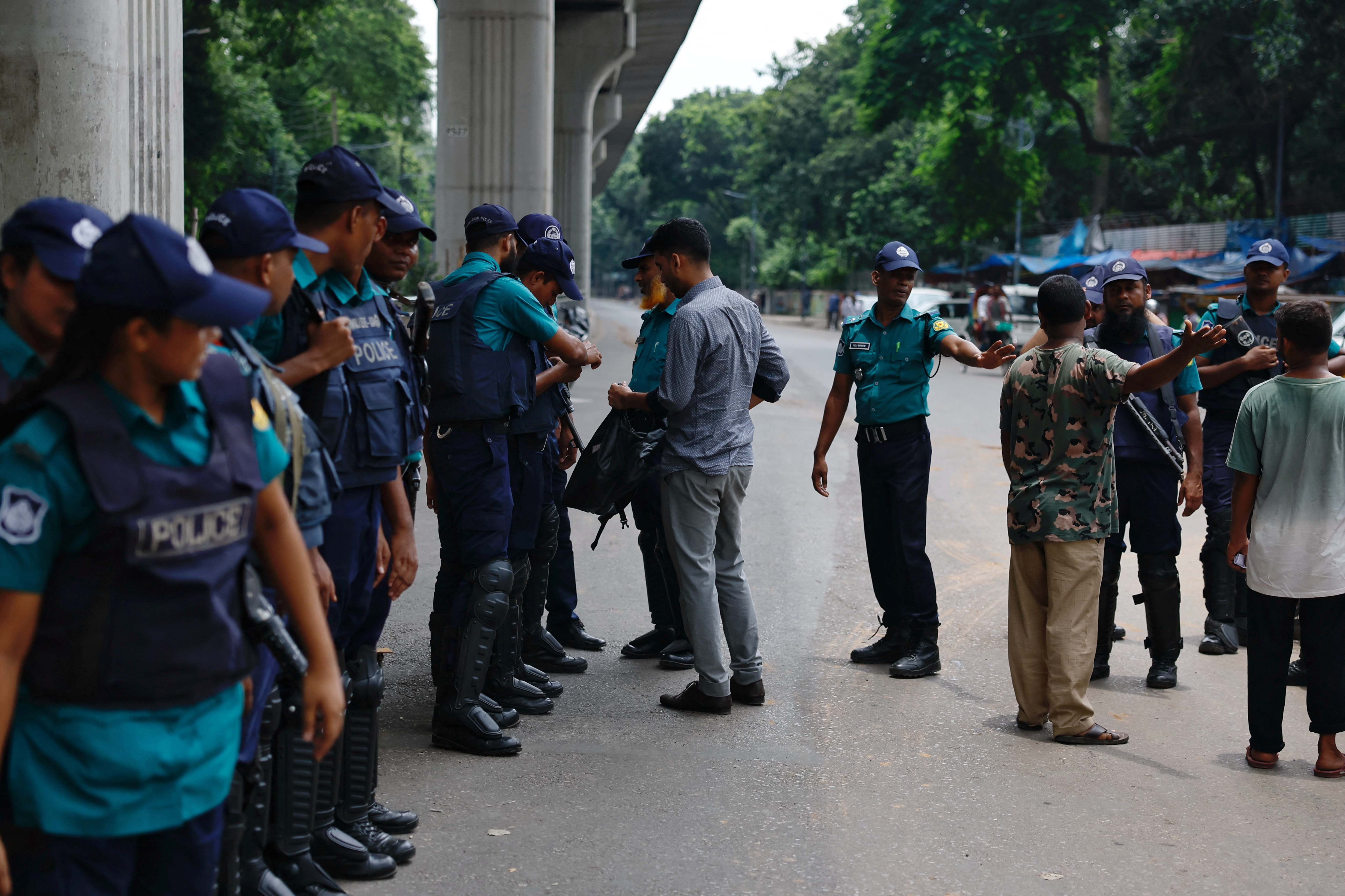 Police check people at the entrance of the campus of the University of Dhaka, a day after the clash between Bangladesh Chhatra League and anti-quota protesters, in Dhaka