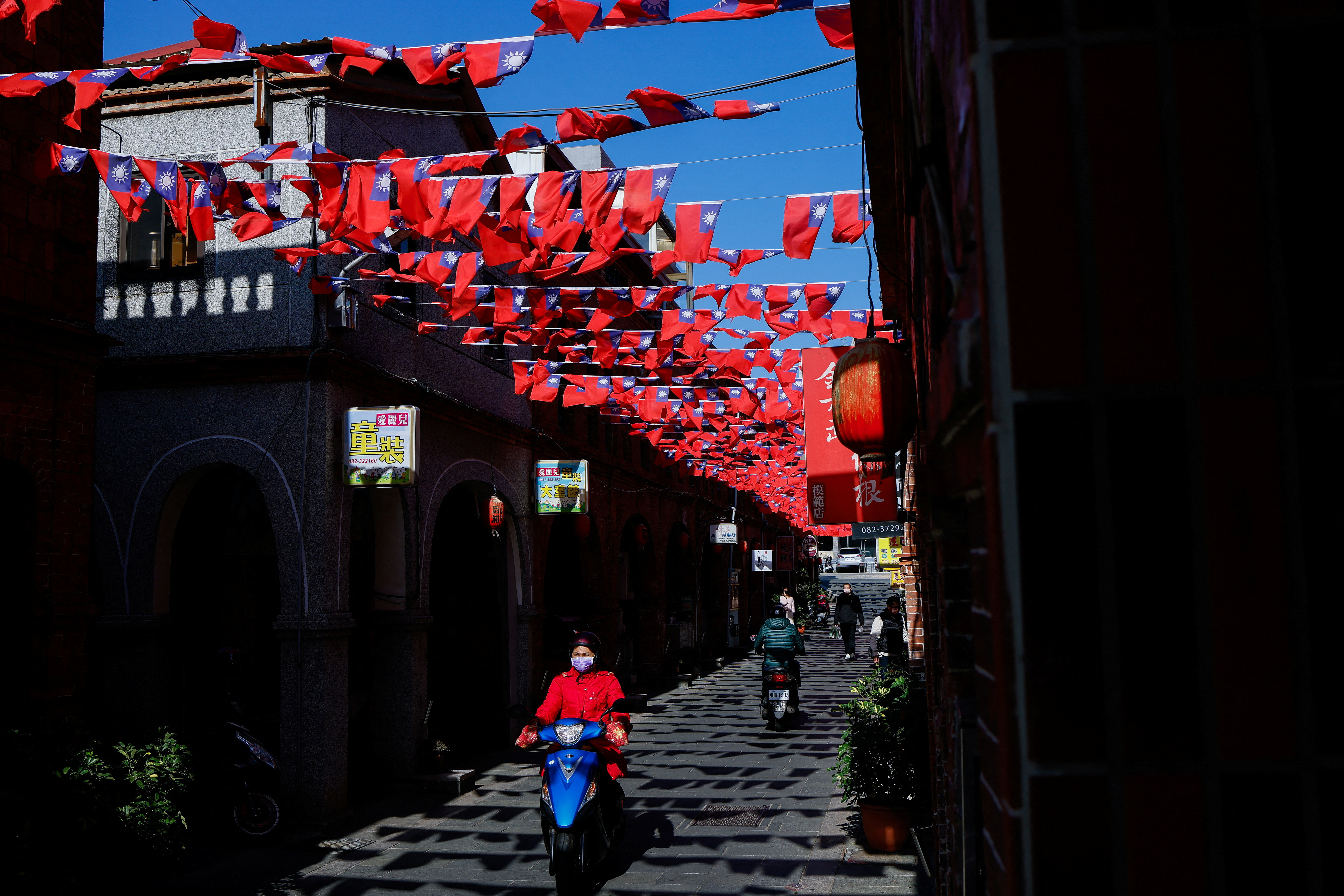 People drive pass a street decorated with Taiwanese flags in Kinmen