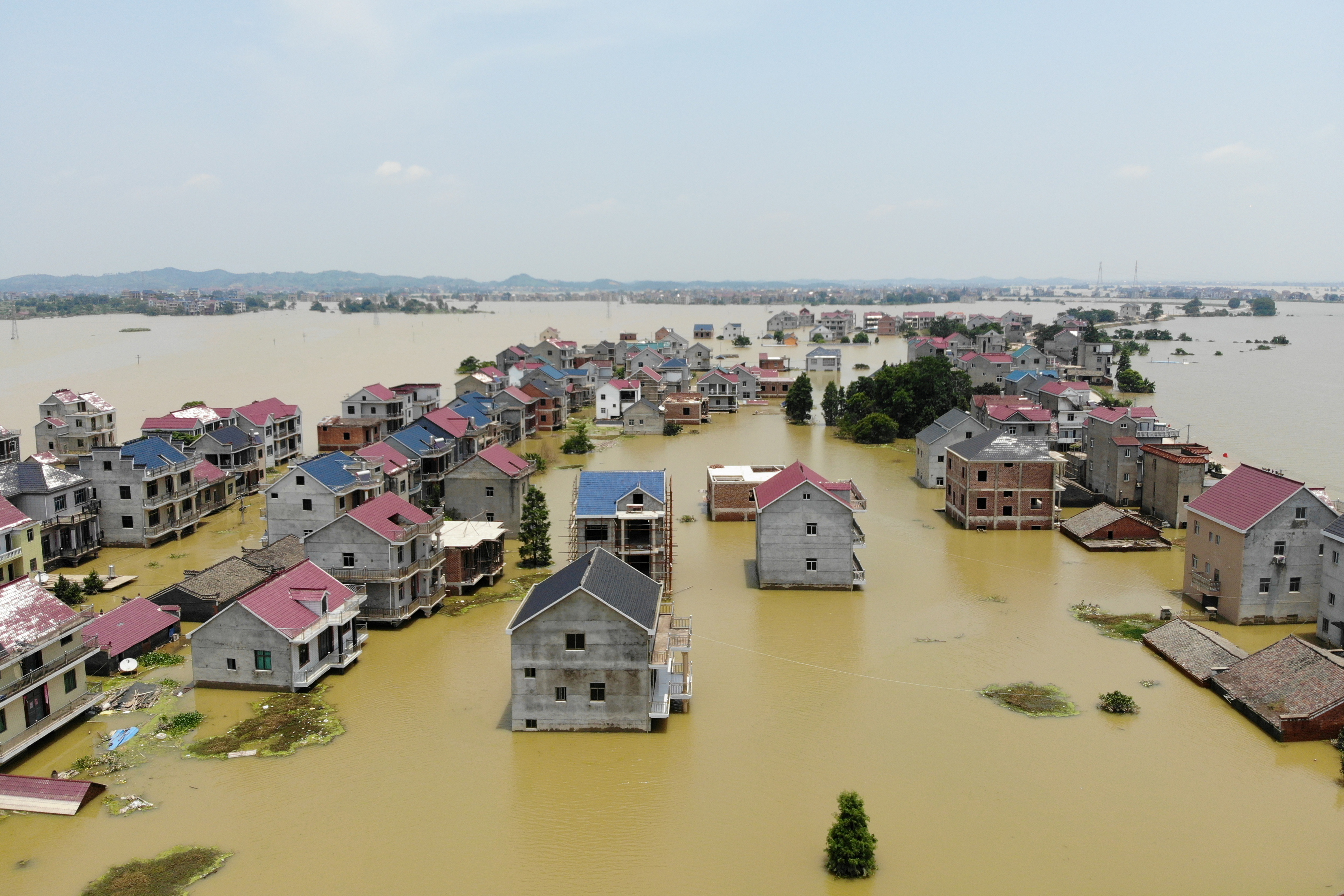 Buildings and farmlands are seen partially submerged in floodwaters following heavy rainfall in Poyang county of Jiangxi