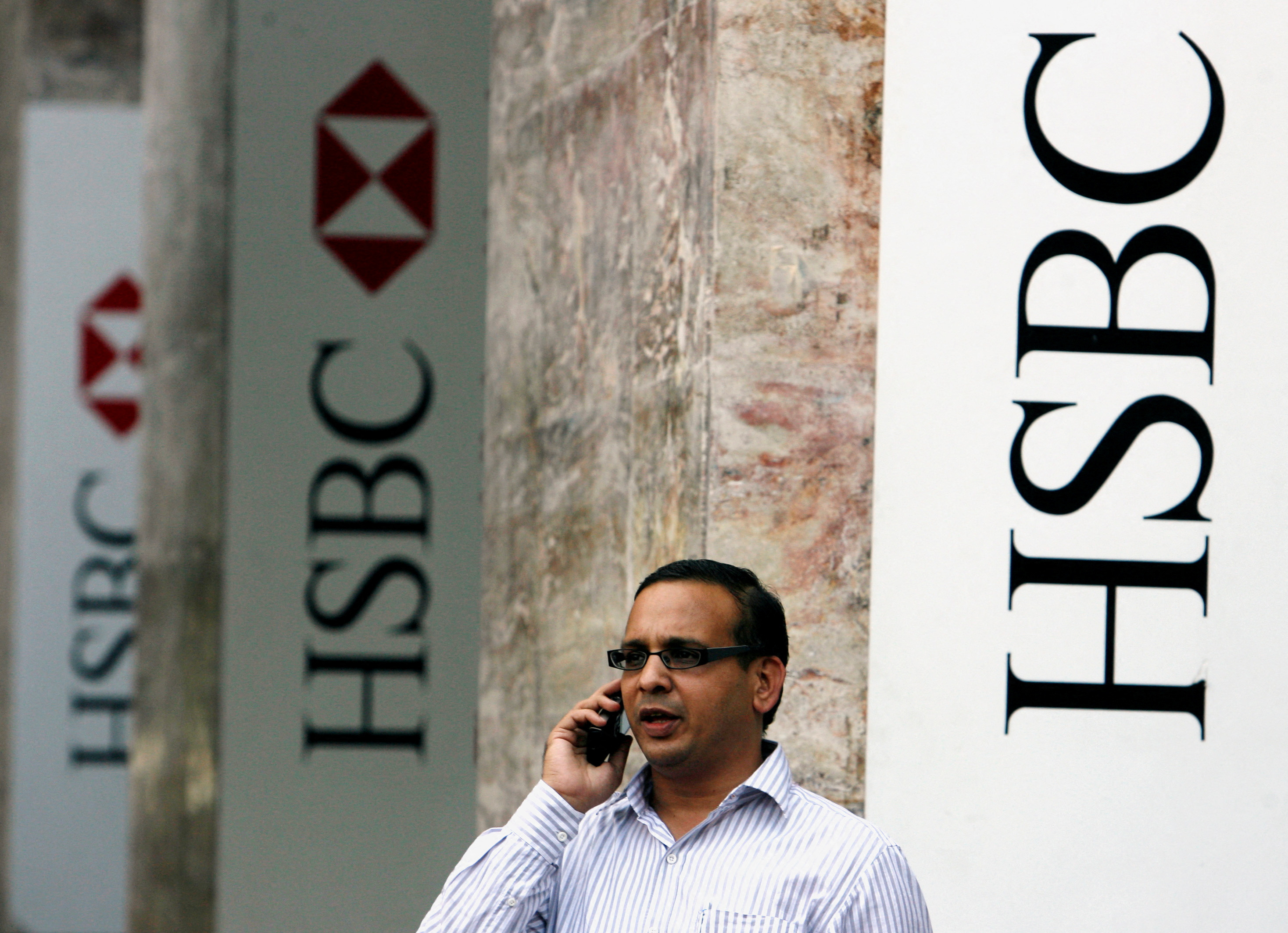 A man speaks on a mobile phone in front of the head office of HSBC bank in Mumbai