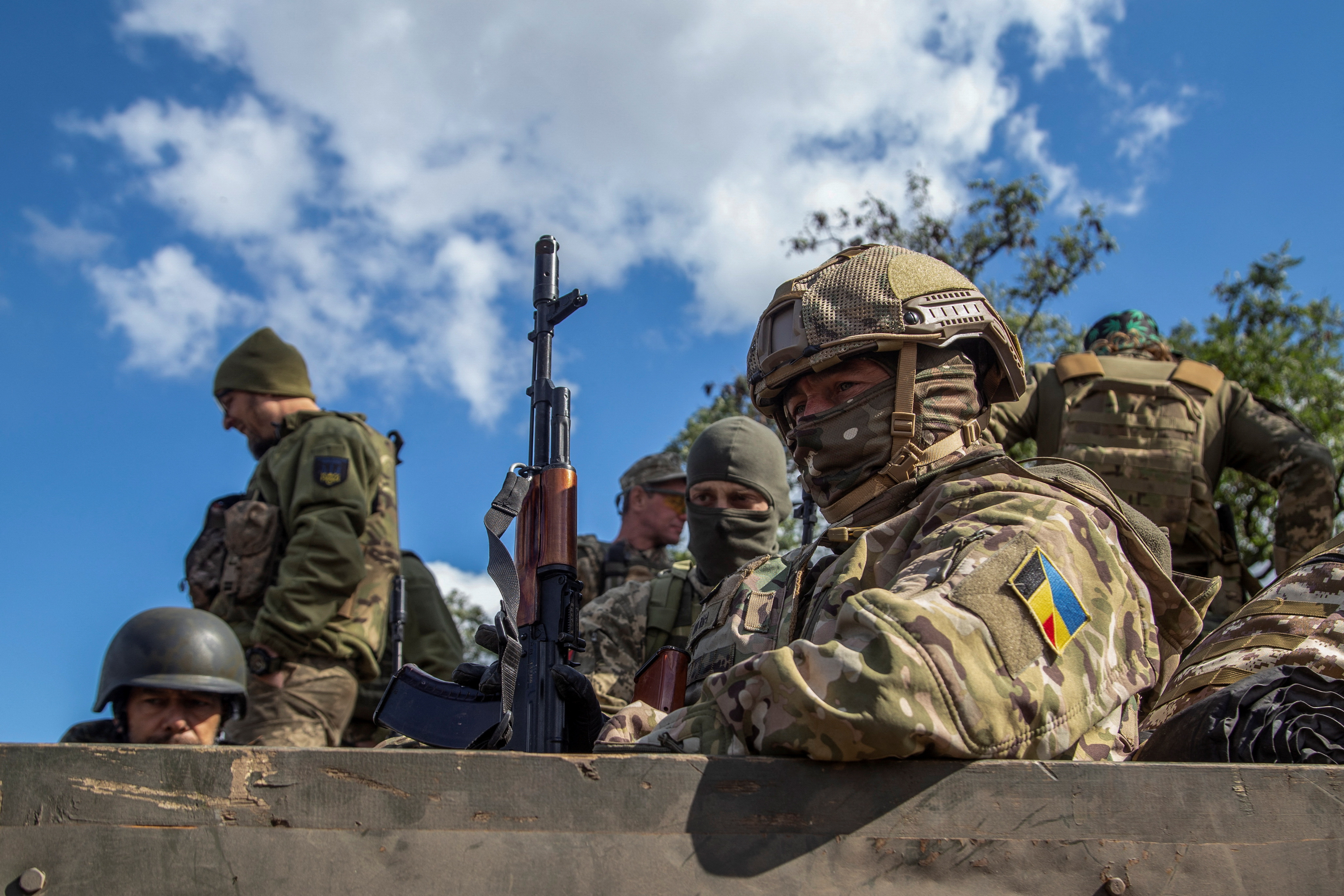 Ukrainian service members ride in a military vehicle in Kharkiv region