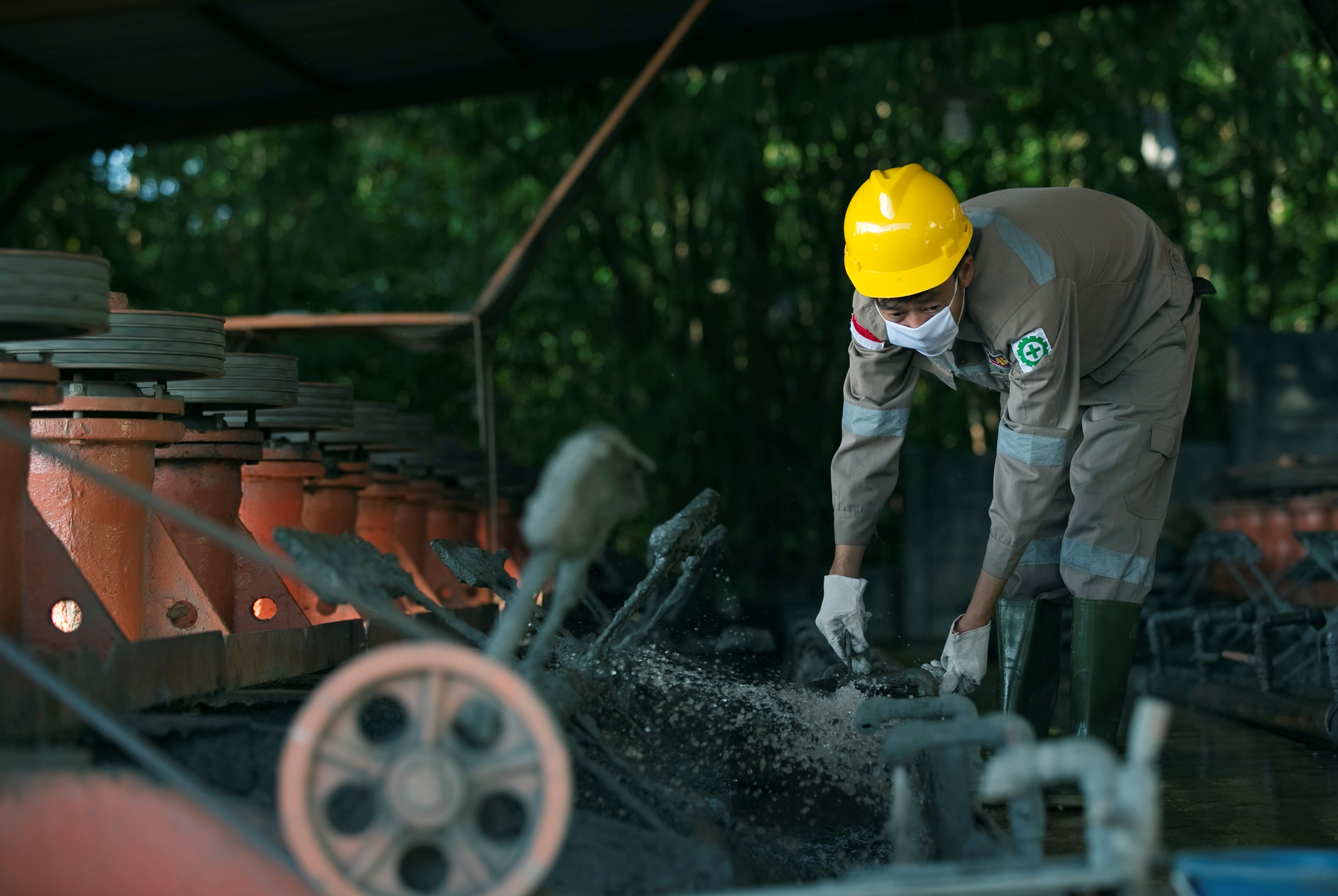A worker adjusts machinery used to extract lead and zinc from ore at a smelter owned by Lumbung Mineral Sentosa in Bogor regency