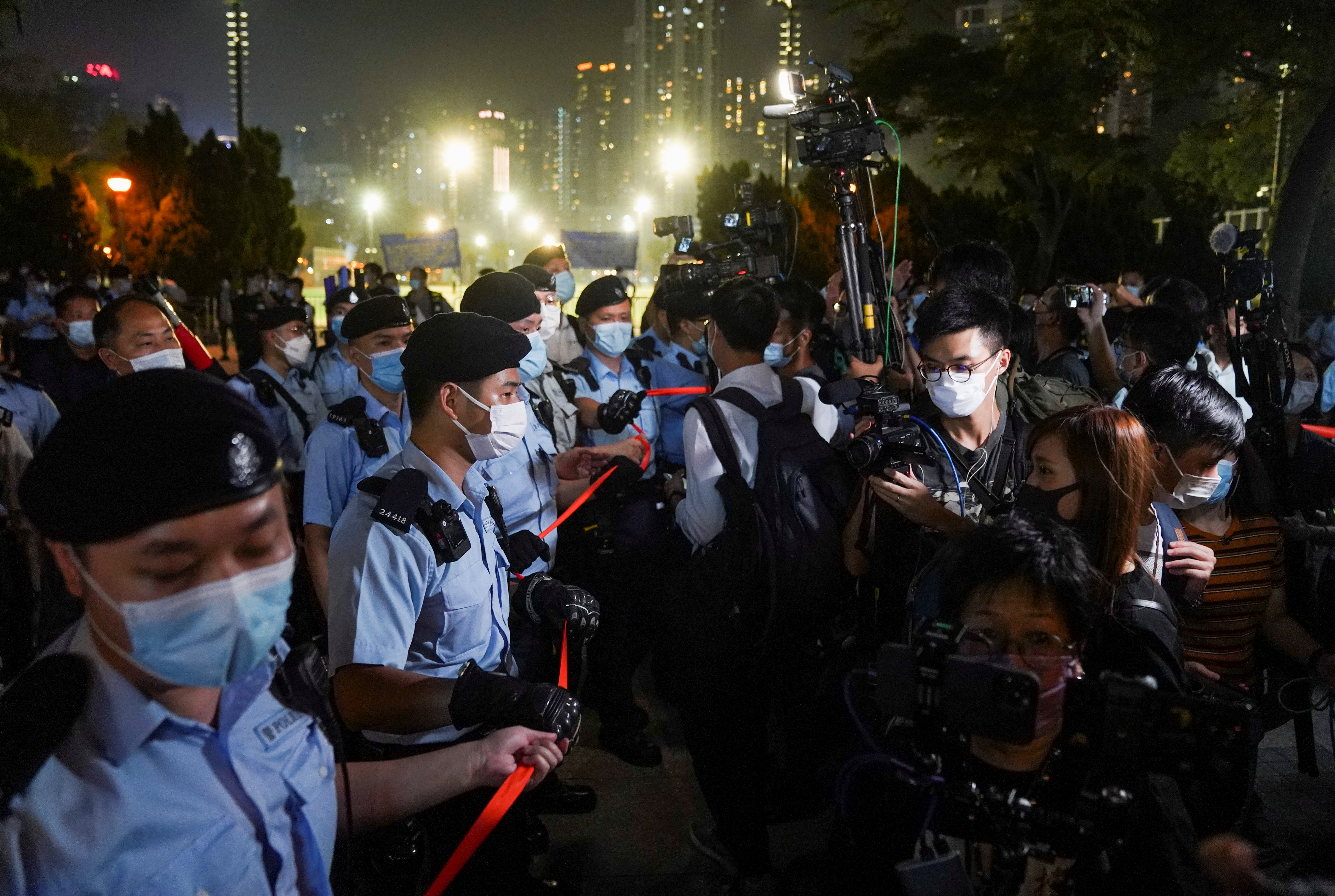 People look at police officers standing guard at Victoria Park on the 32nd anniversary of the crackdown on pro-democracy demonstrators at Beijing's Tiananmen Square in 1989, in Hong Kong, China June 4, 2021. REUTERS/Lam Yik