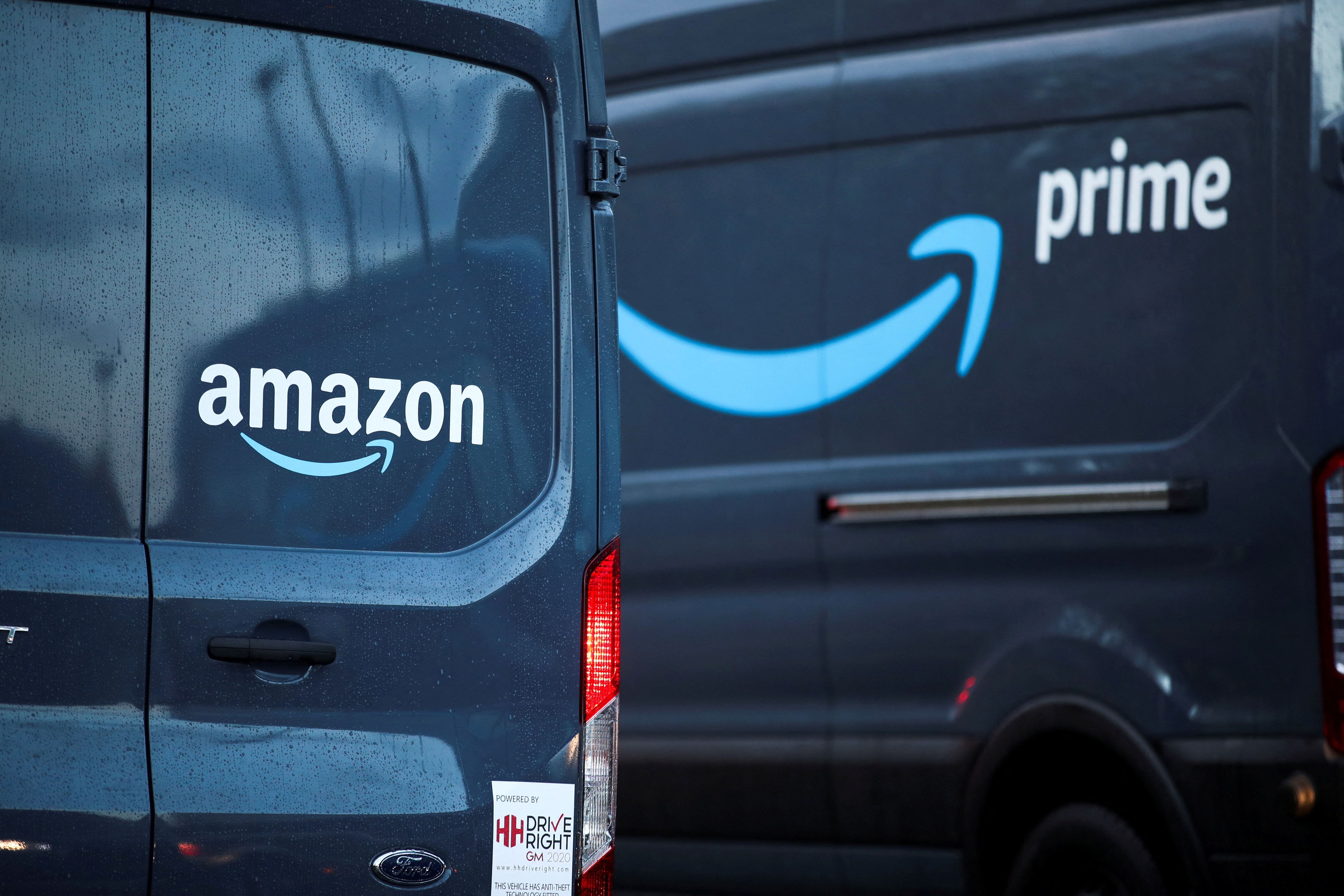 Logos of Amazon and Amazon Prime are pictured on vehicles outside the Amazon Fulfilment Centre in Altrincham