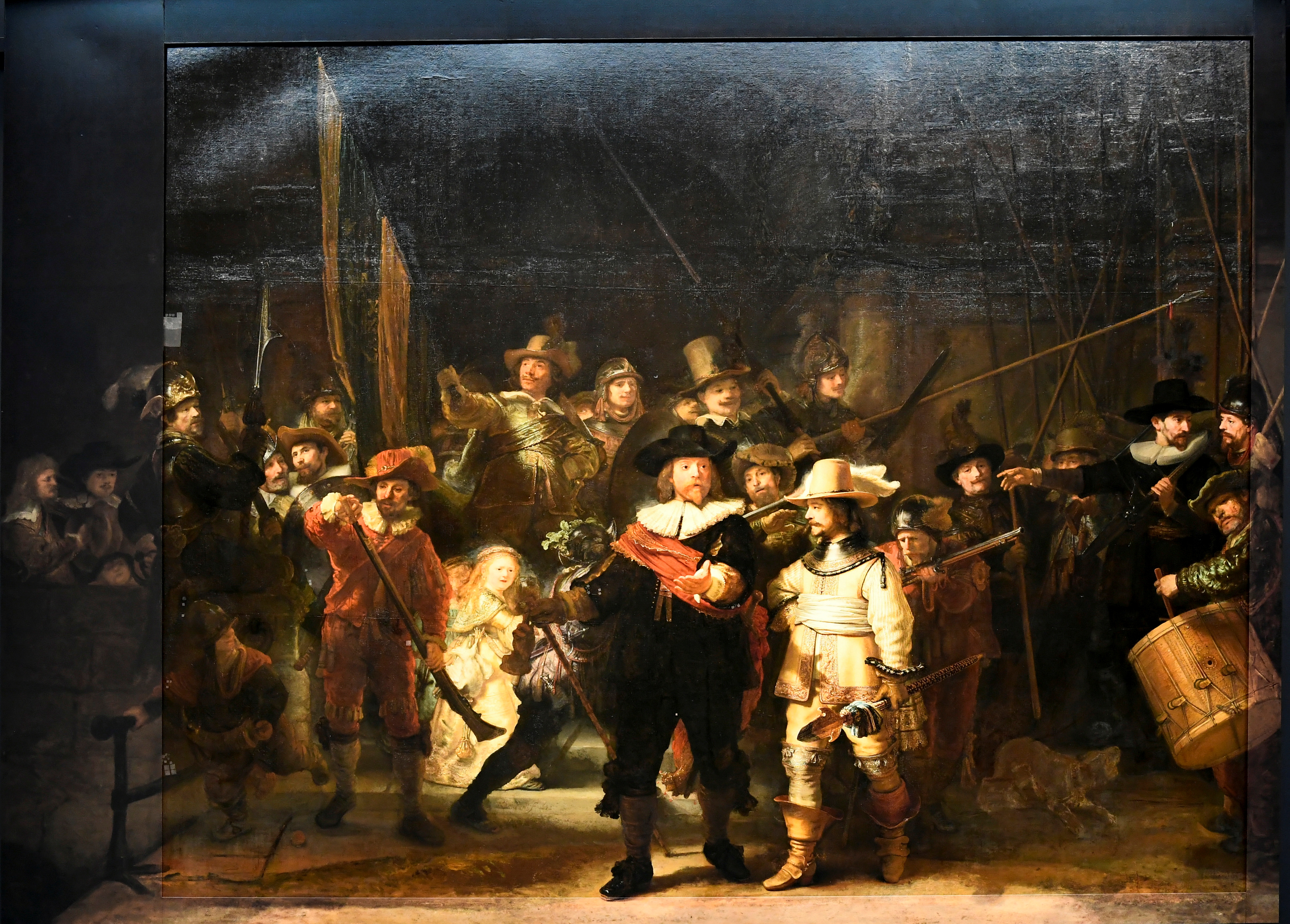 Rembrandt's famed Night Watch is seen back on display for the first time in 300 years, in what researchers say is its original size, with missing parts temporarily restored in an exhibition aided by artificial intelligence at Rijksmuseum in Amsterdam, Netherlands June 23, 2021. REUTERS/Piroschka van de Wouw