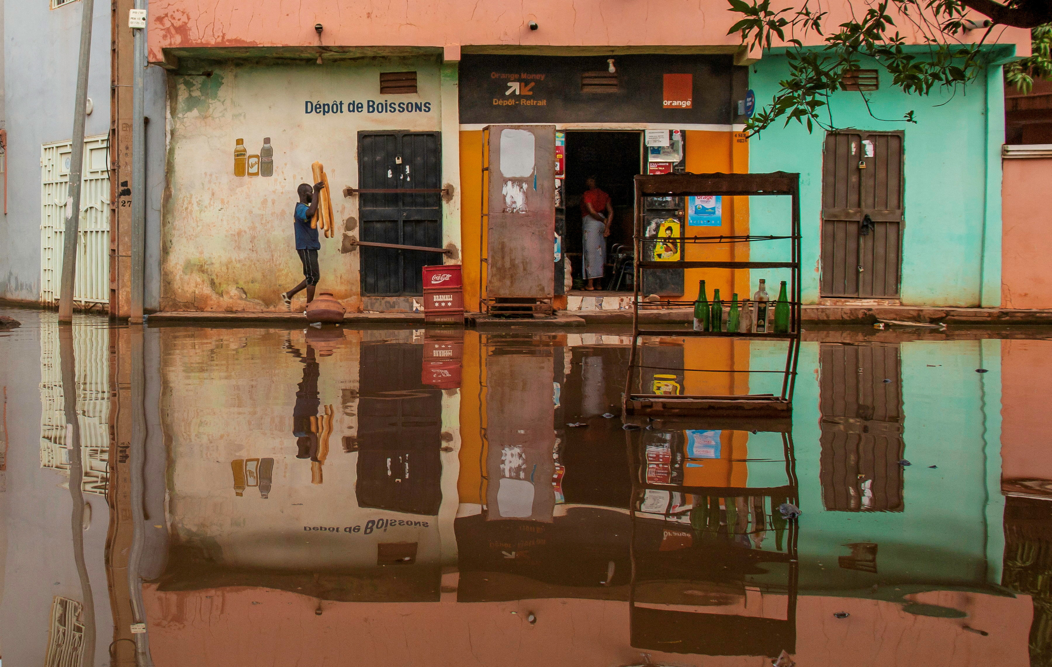 A man carries bread as he walks towards a grocery store, on a flooded street in Bamako, Mali September 23, 2024.REUTERS/Aboubacar Traore