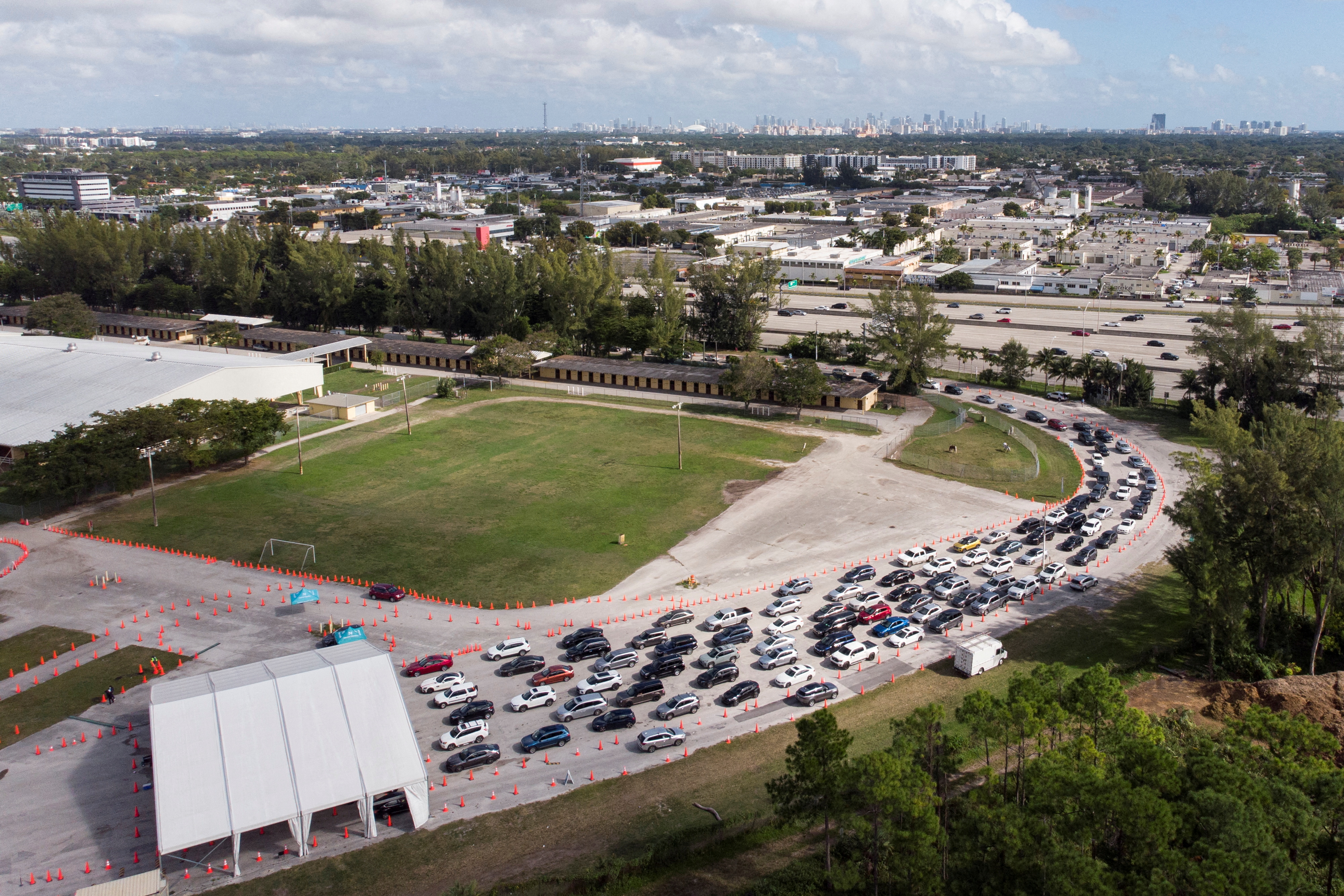 Cars wait in line at a COVID-19 drive-through testing site at Tropical Park, in Miami, Florida, U.S. December 17, 2021. REUTERS/Marco Bello     