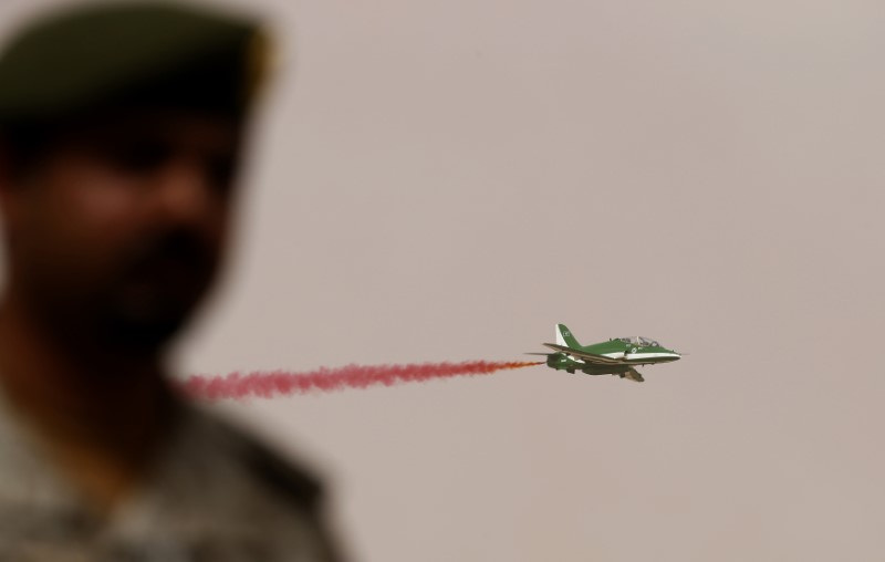 A member of Saudi security forces attends Abdullah's Sword military drill as a jet flies by in Hafar Al-Batin, near the border with Kuwait