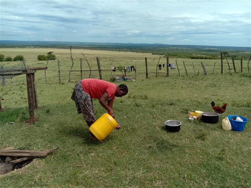 Mama Yianti washes dishes outsides her home near the Enonkishu Conservancy, where she is one of few Maasai women who are given a say on how land is managed, in Olchoro Oroiwua village, Kenya, April 19, 2022. Thomson Reuters Foundation/Wesley Langat