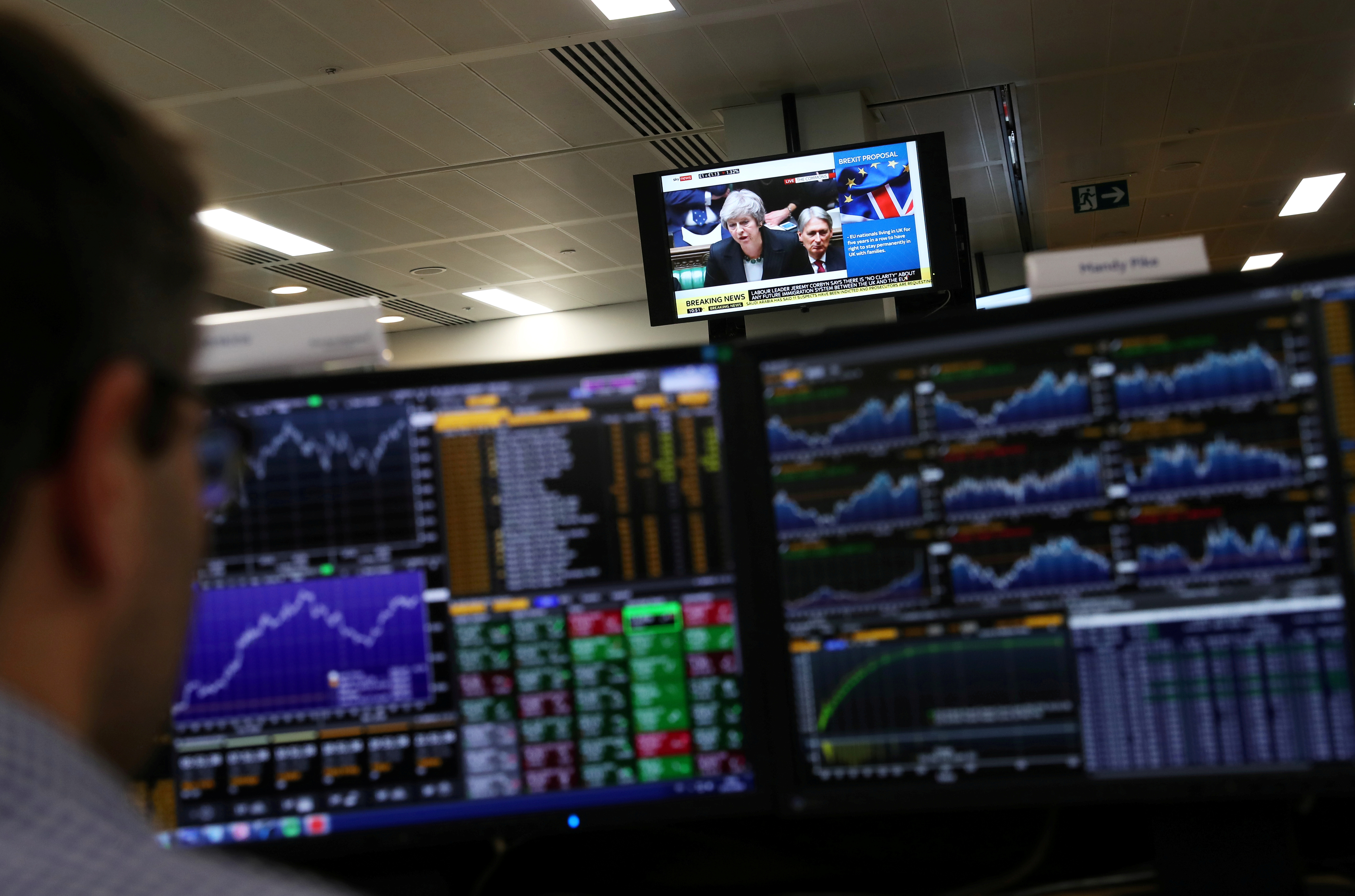 An investment manager, in the office of Aberdeen Standard Investments, watches his screen in London, Britain